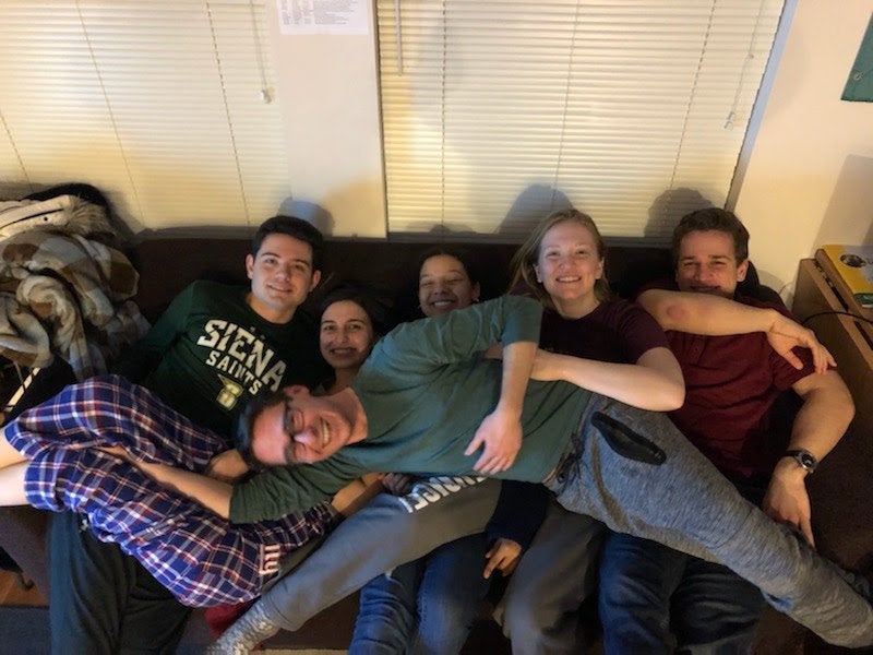 6 friends on couch laughing