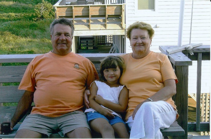 child on porch with women and man