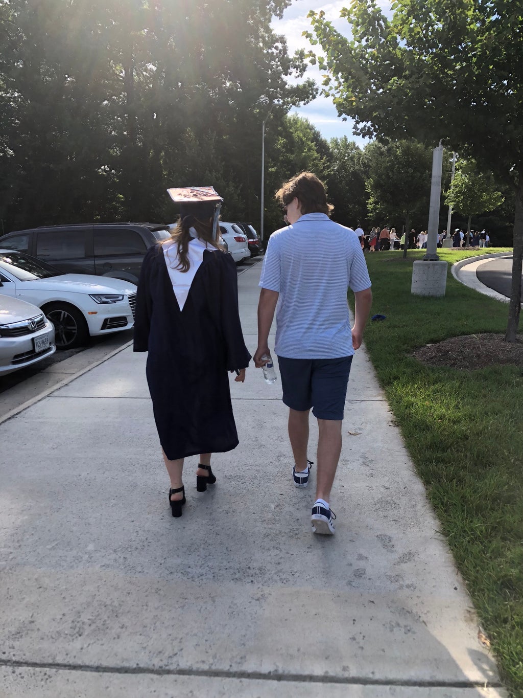 brother and sister walking towards graduation