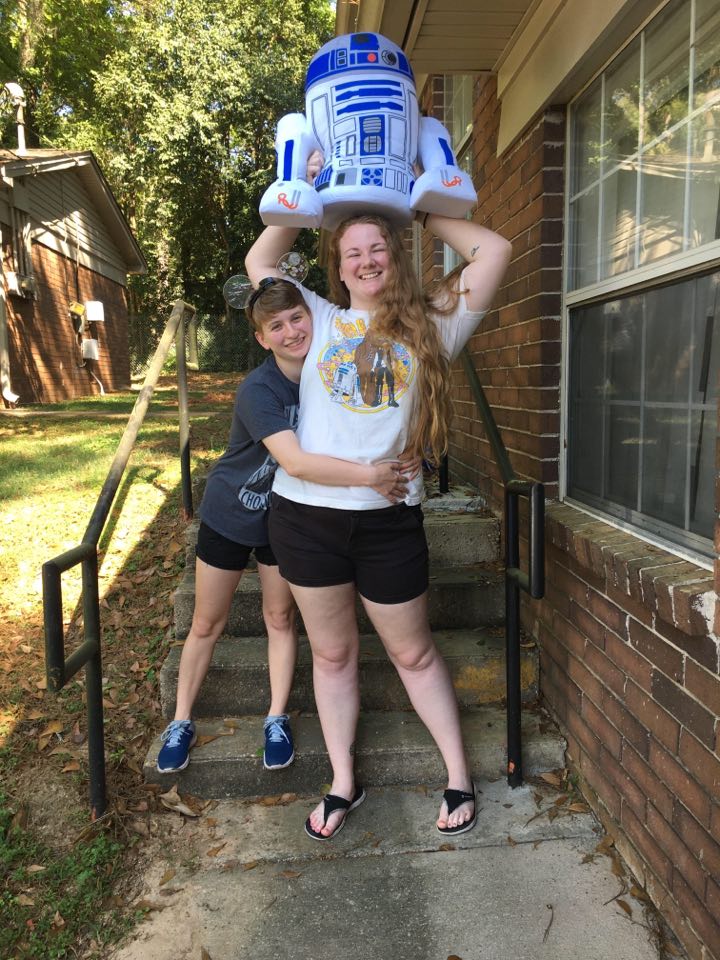 Devon and Lindsey pose with Star Wars shirts and a stuffed R2-D2
