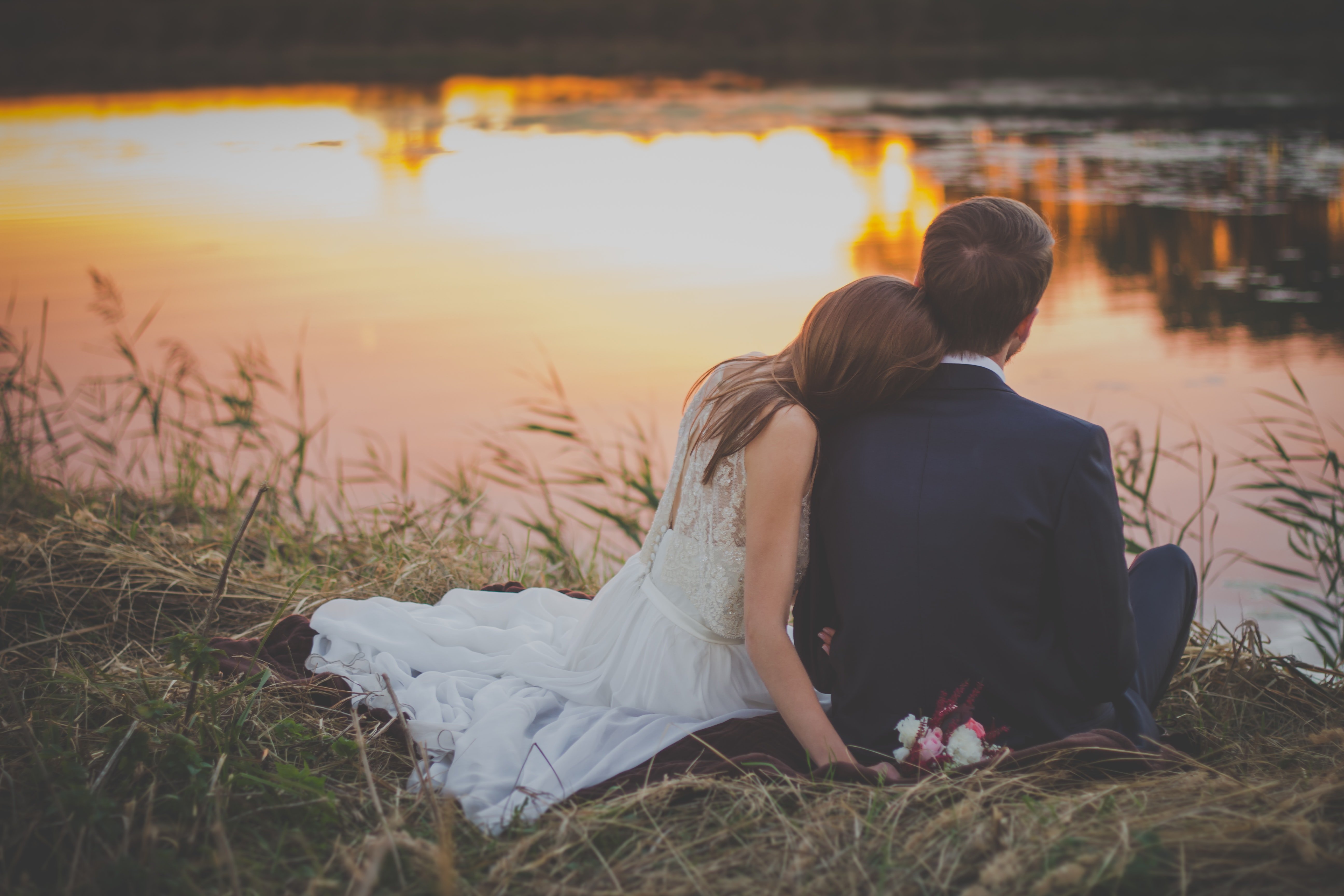Bride and Groom sitting near a lake