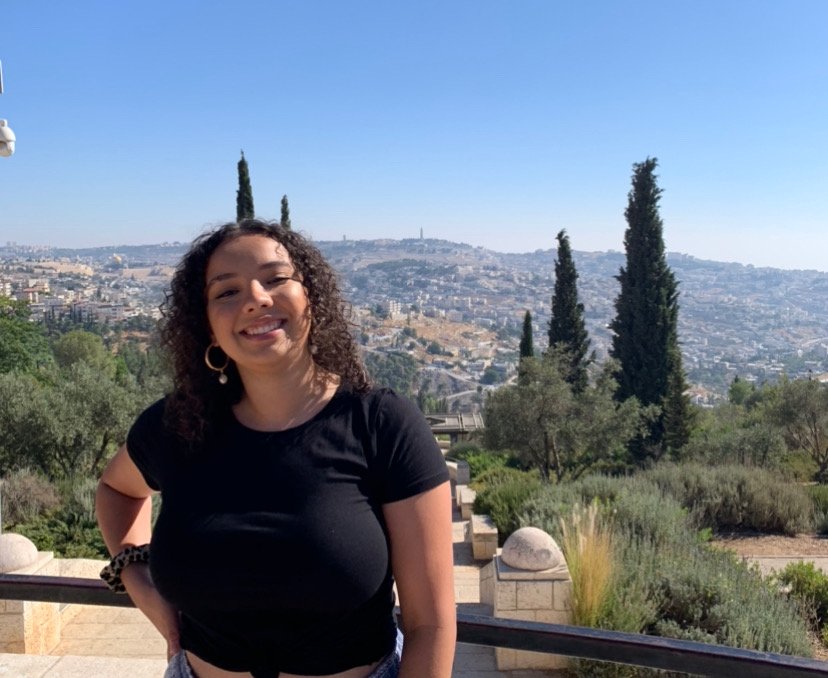 a picture of Kayla Francis in front of greenery in a black shirt