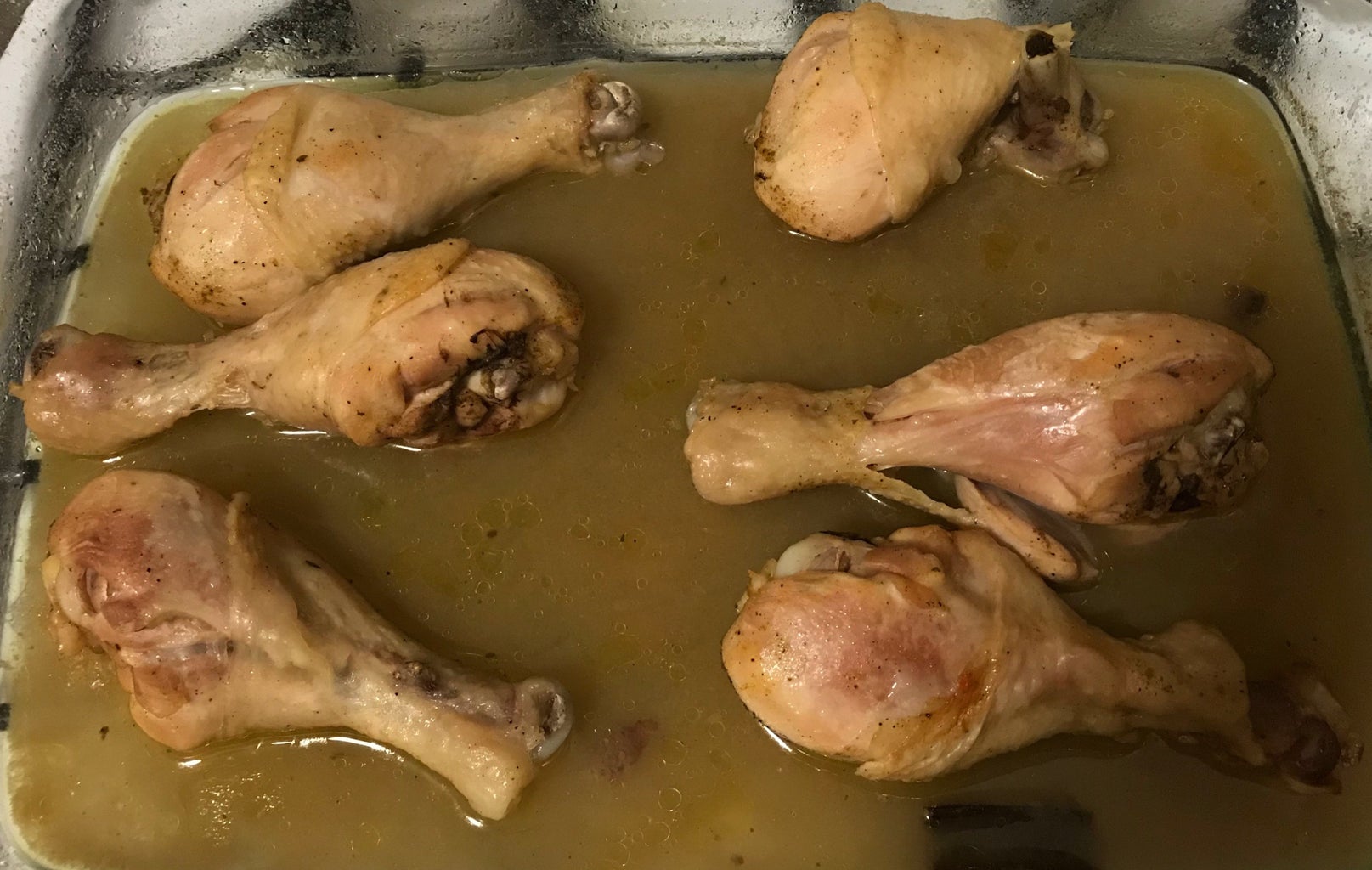 six chicken drum sticks in broth on a tray