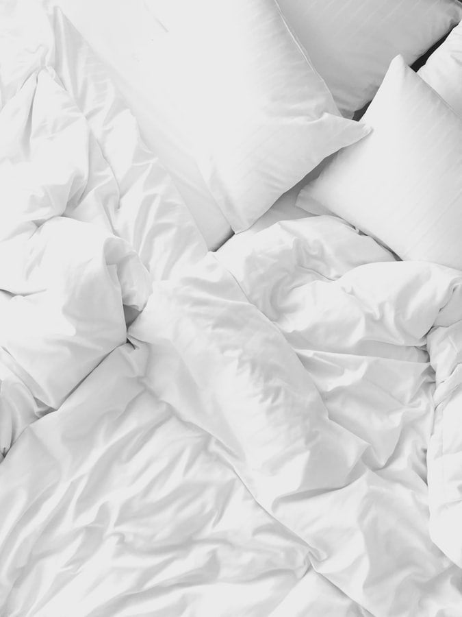 White pillows and rumpled white blankets