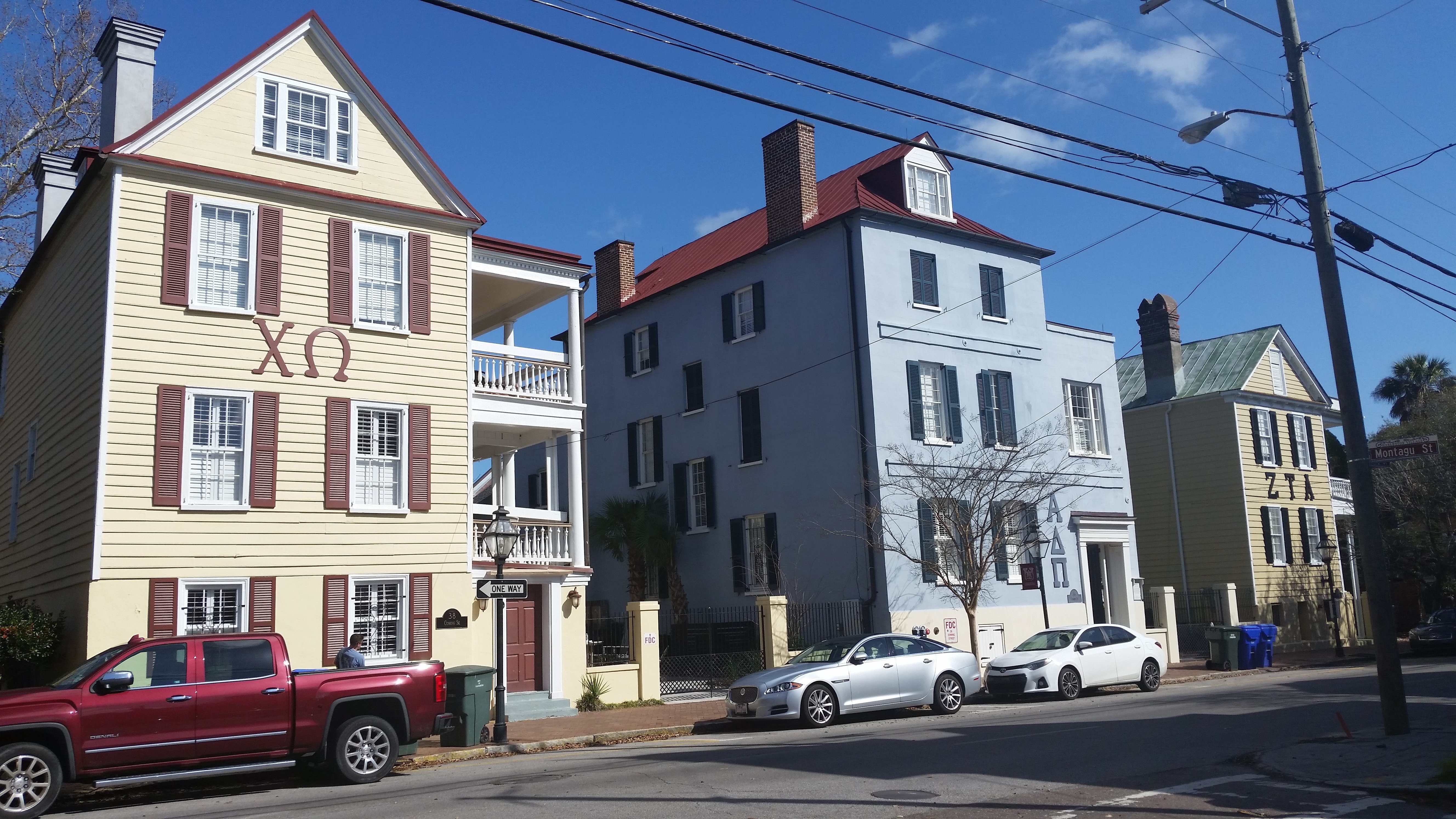 3 sorority houses on a street on a sunny day