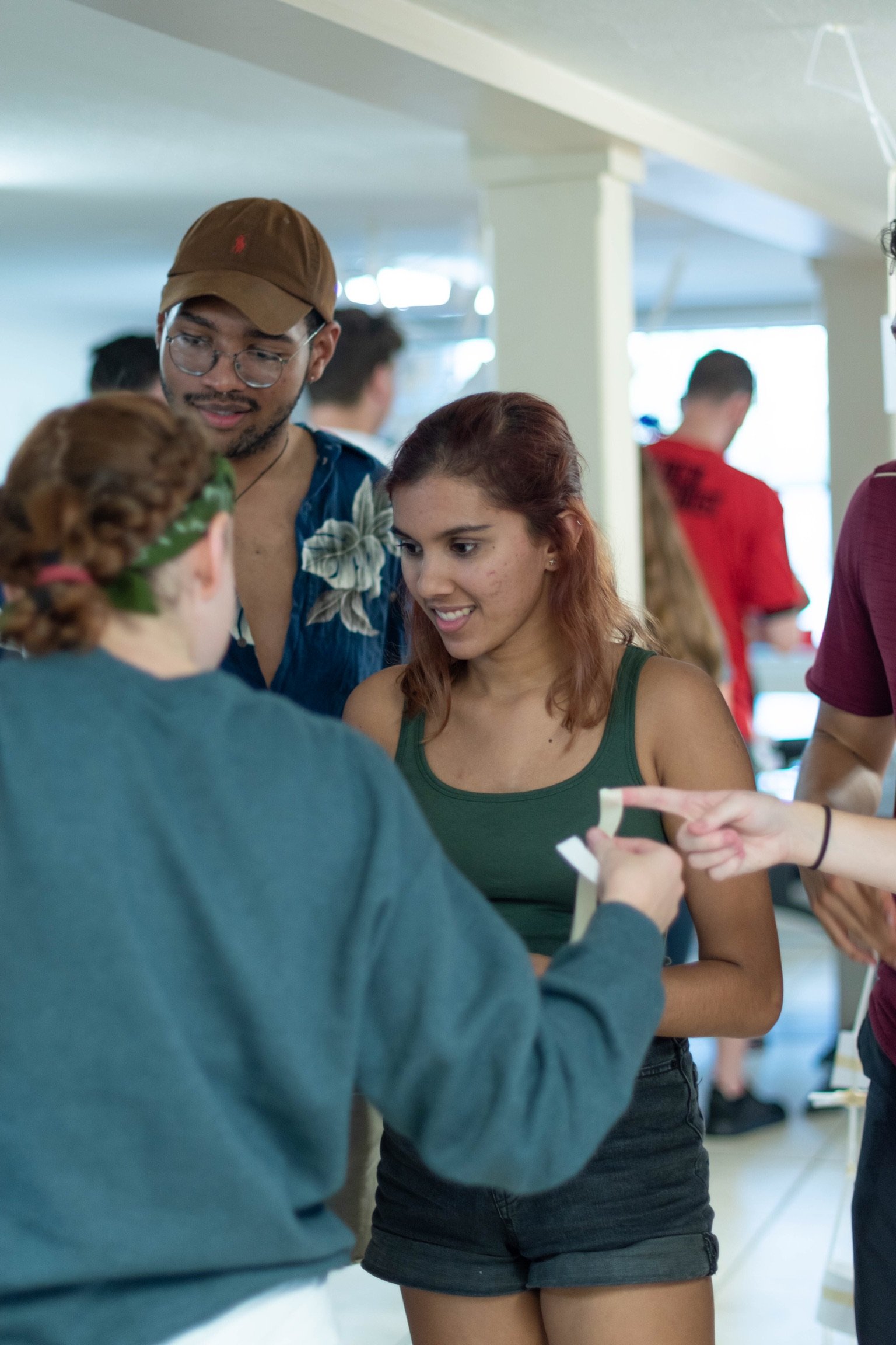Three people (one girl in a green tank top) working on a project together