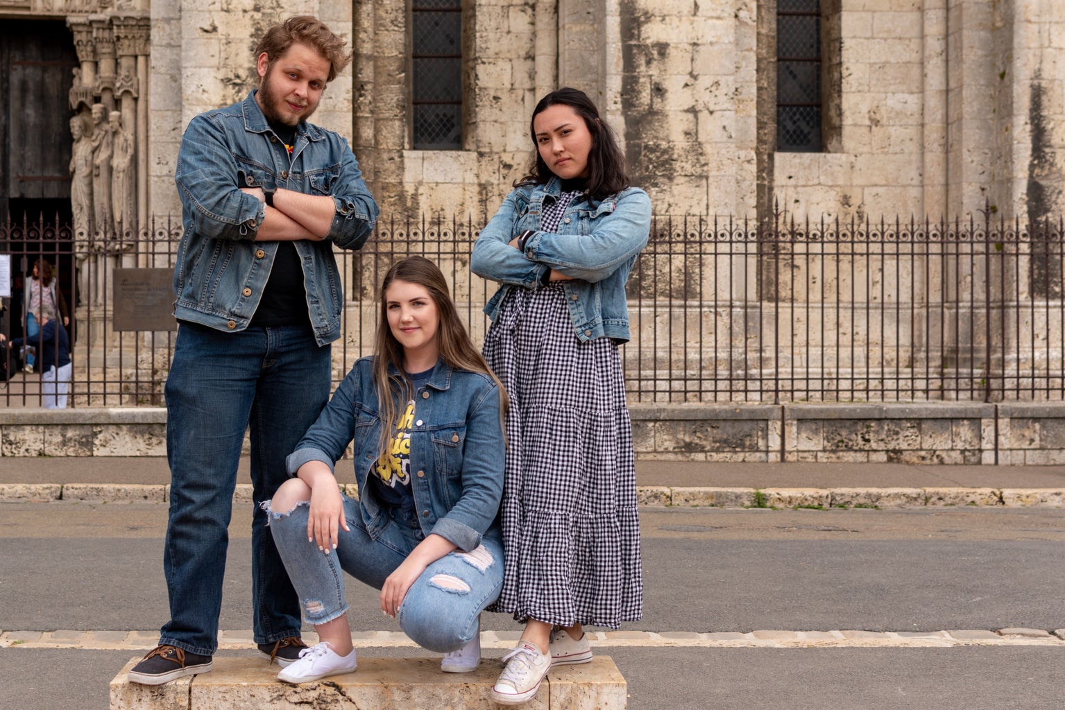 Three people posing in front of a church