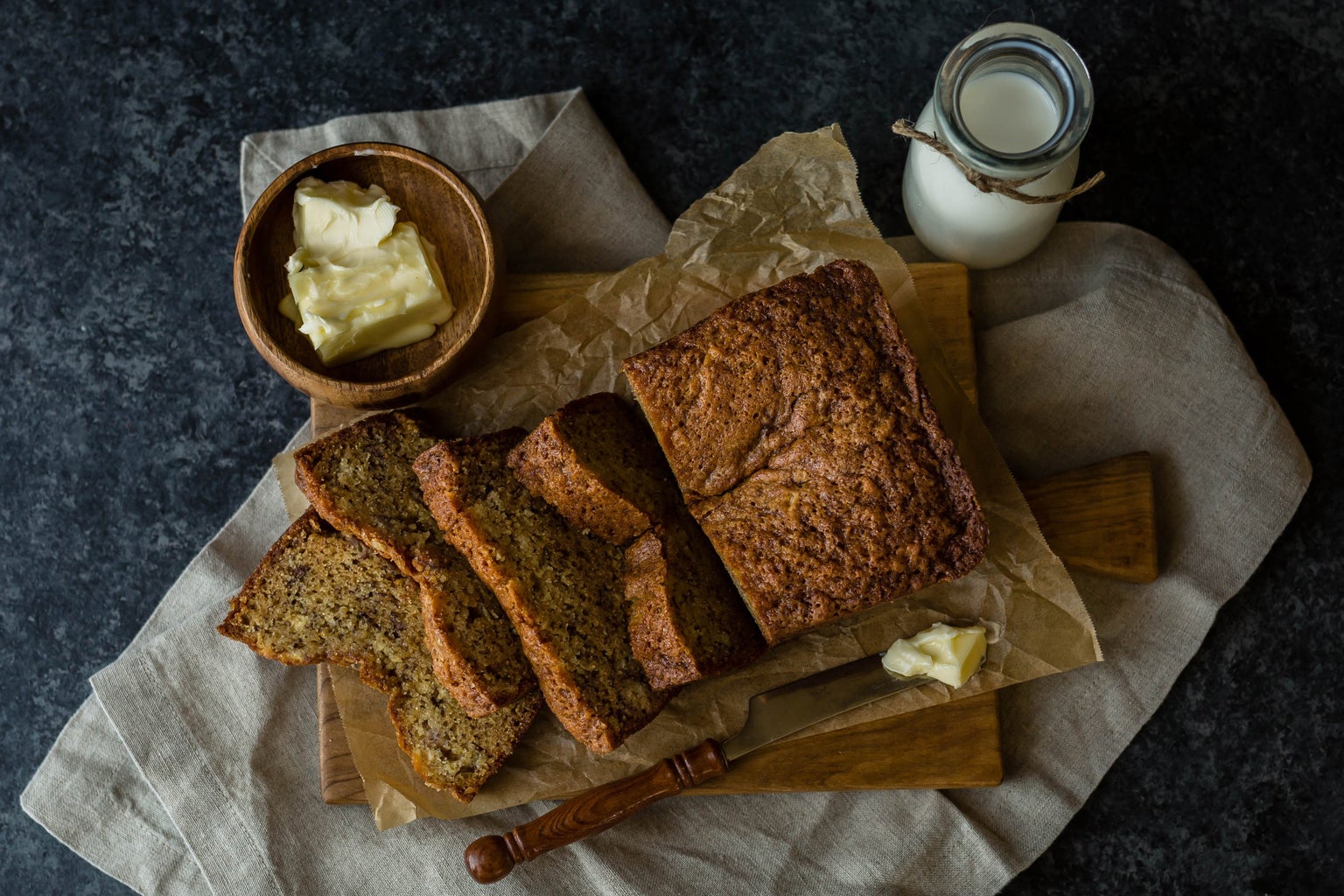 banana bread with butter and milk on the side