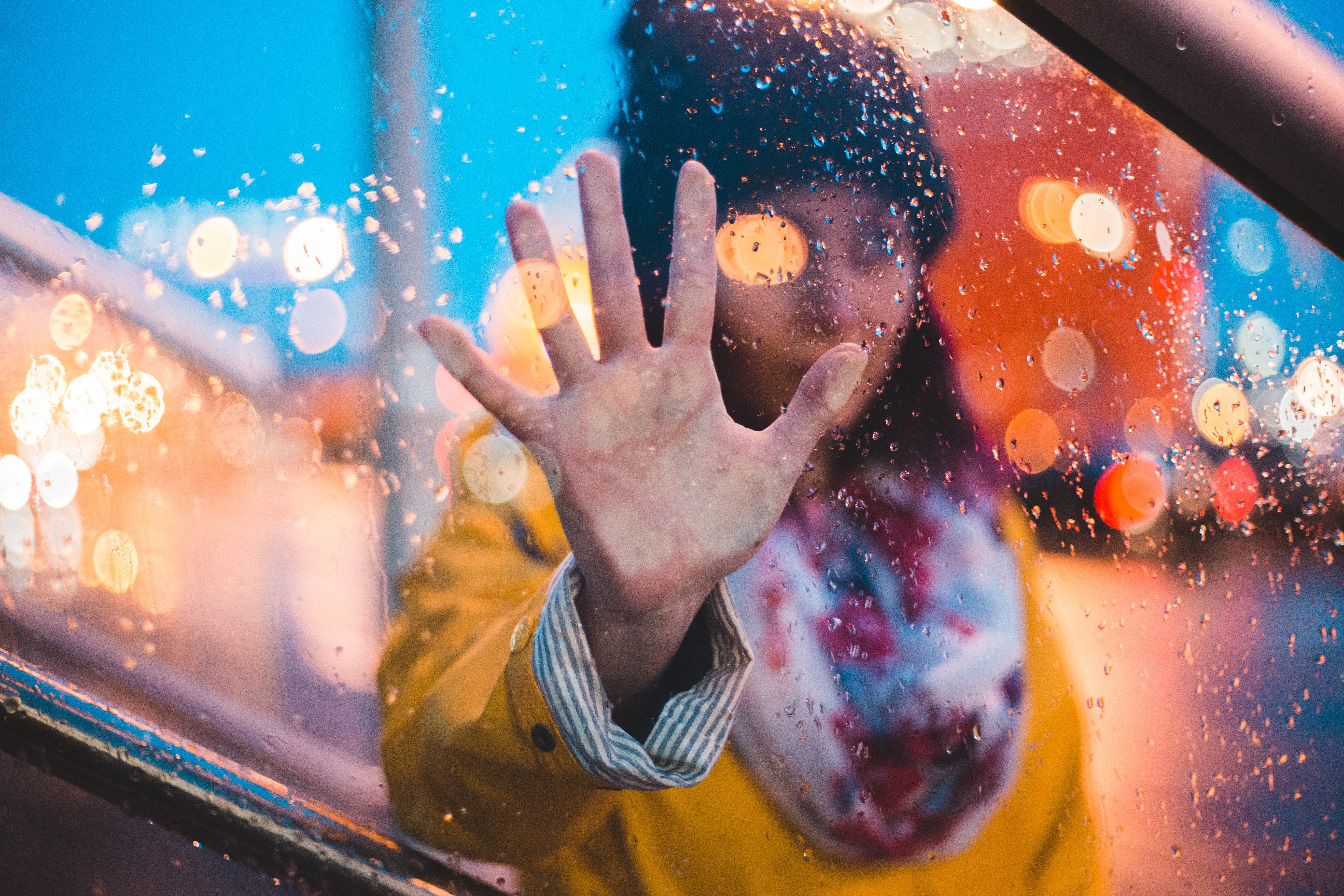 girl with hand on a wet window