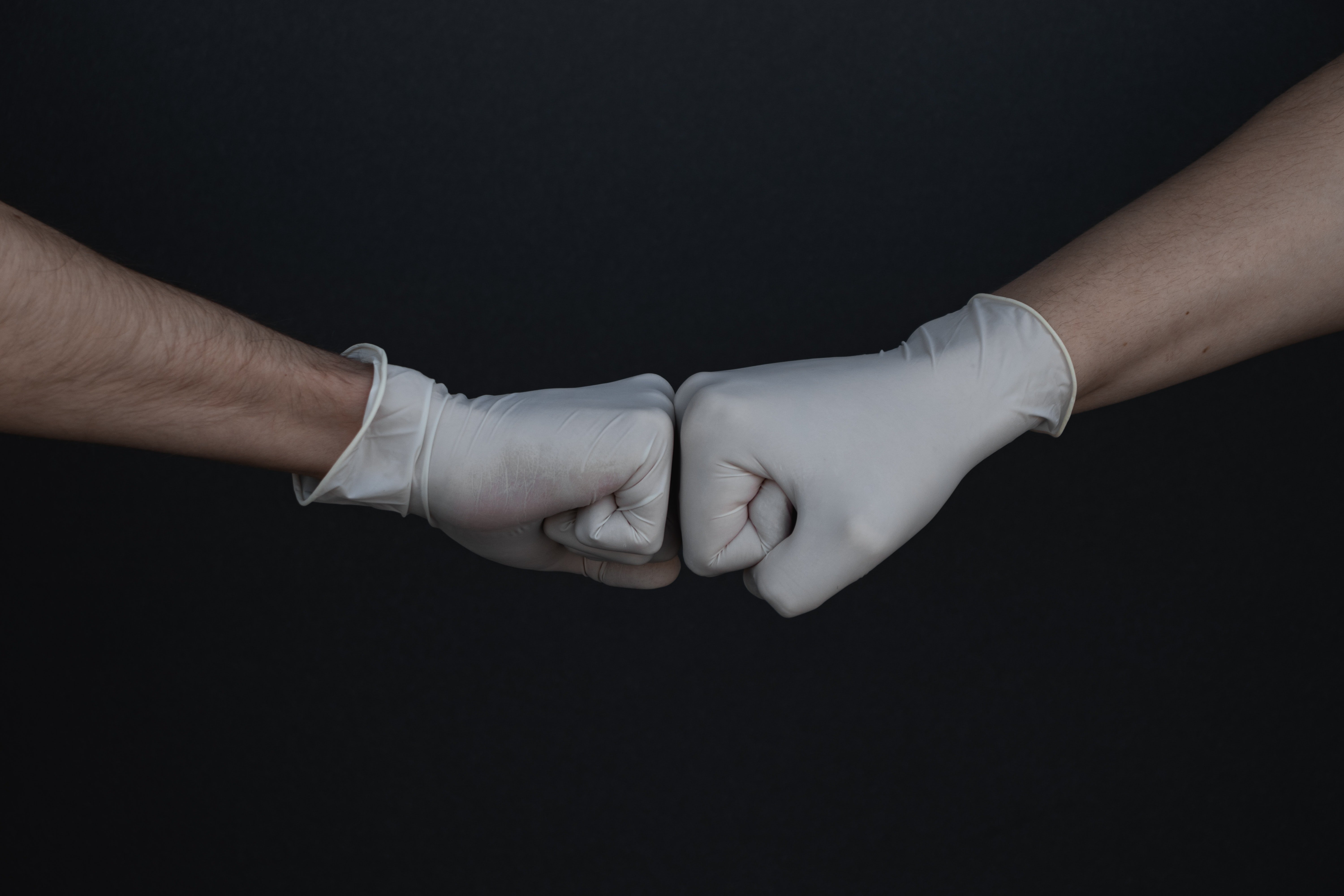hands with gloves on fist bumping