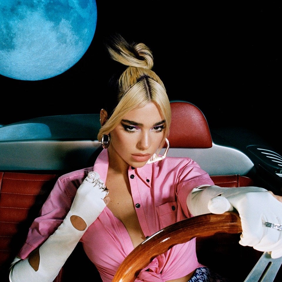 Closeup of Dua Lipa in a pink shirt in a convertible (Future Nostalgia album cover)