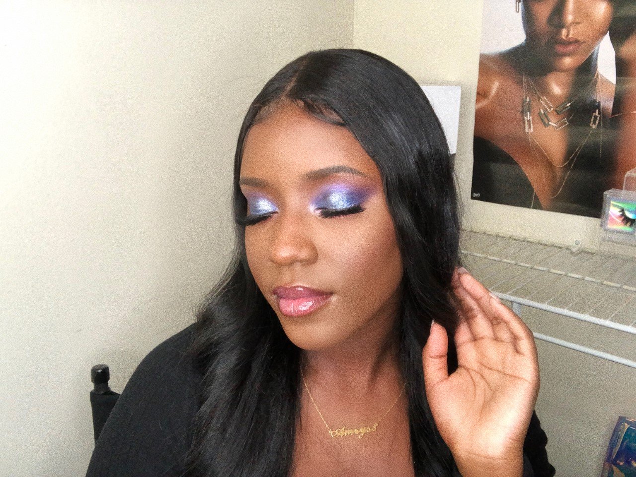 A black girl with her eyes closed touching her hair