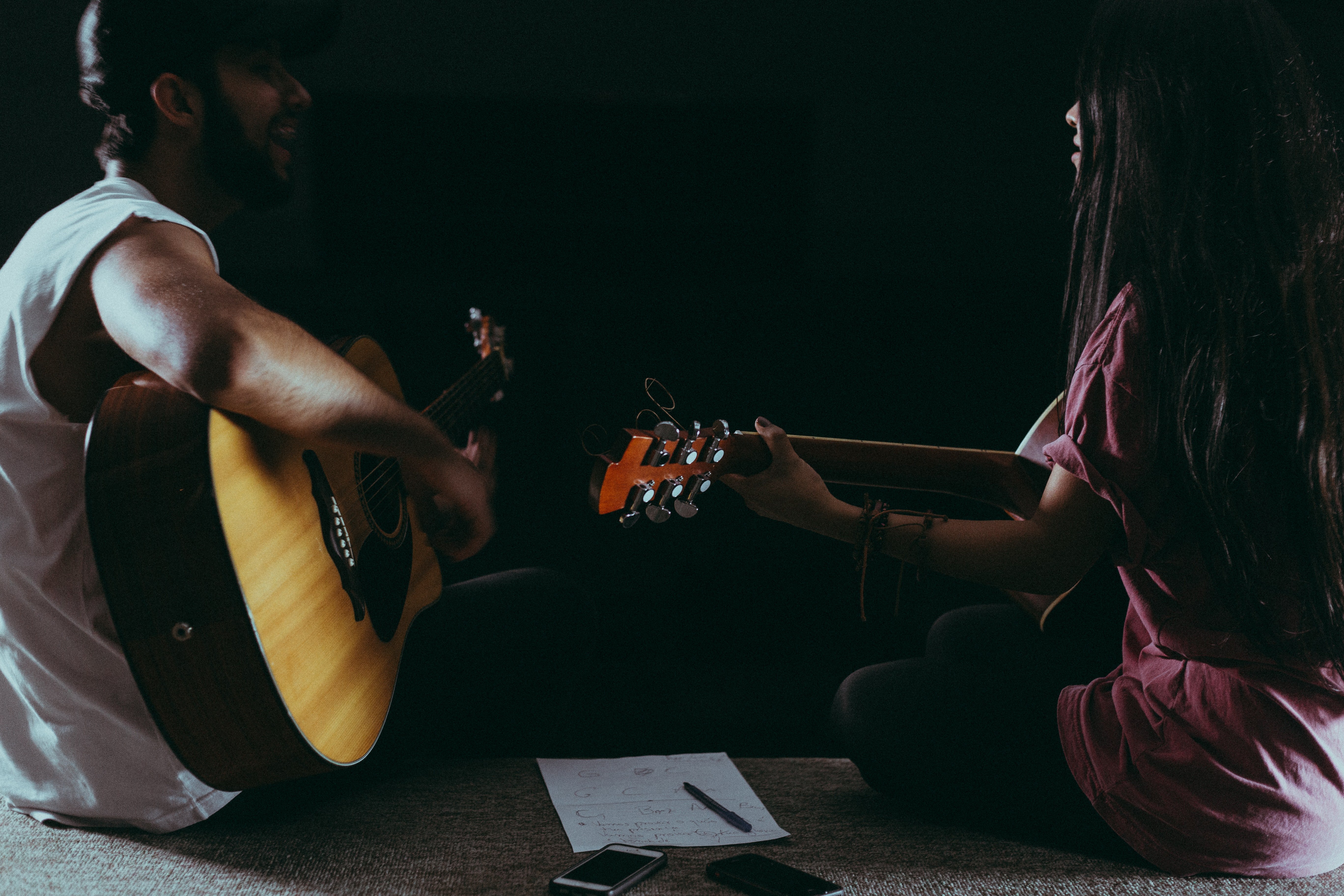man & woman singing & playing guitar
