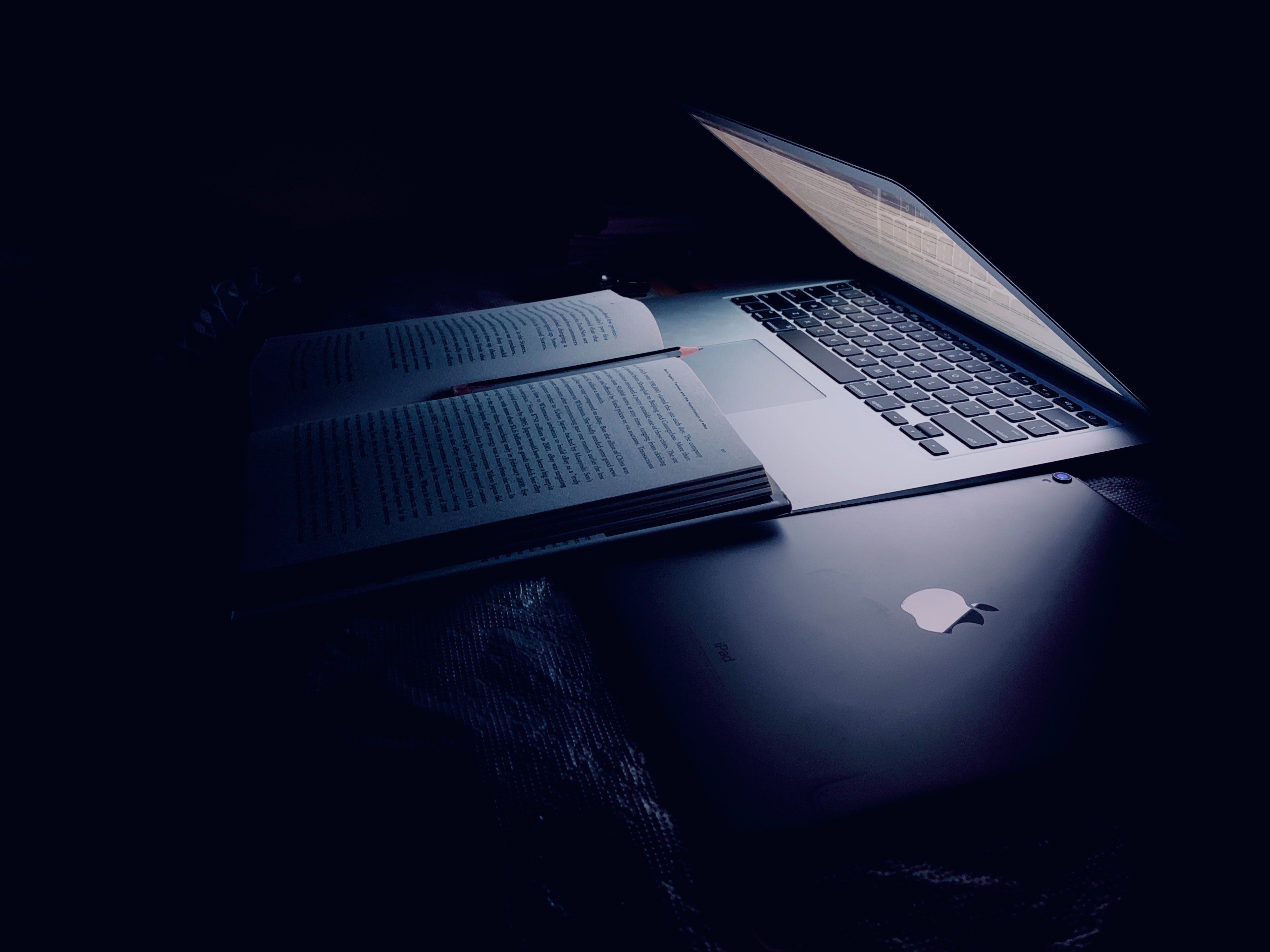 Half closed laptop over book