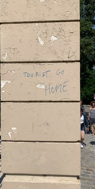 “Tourist go home” written on the outside of a building in Paris, France