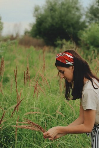 Girl picking up flower with bandana on the head