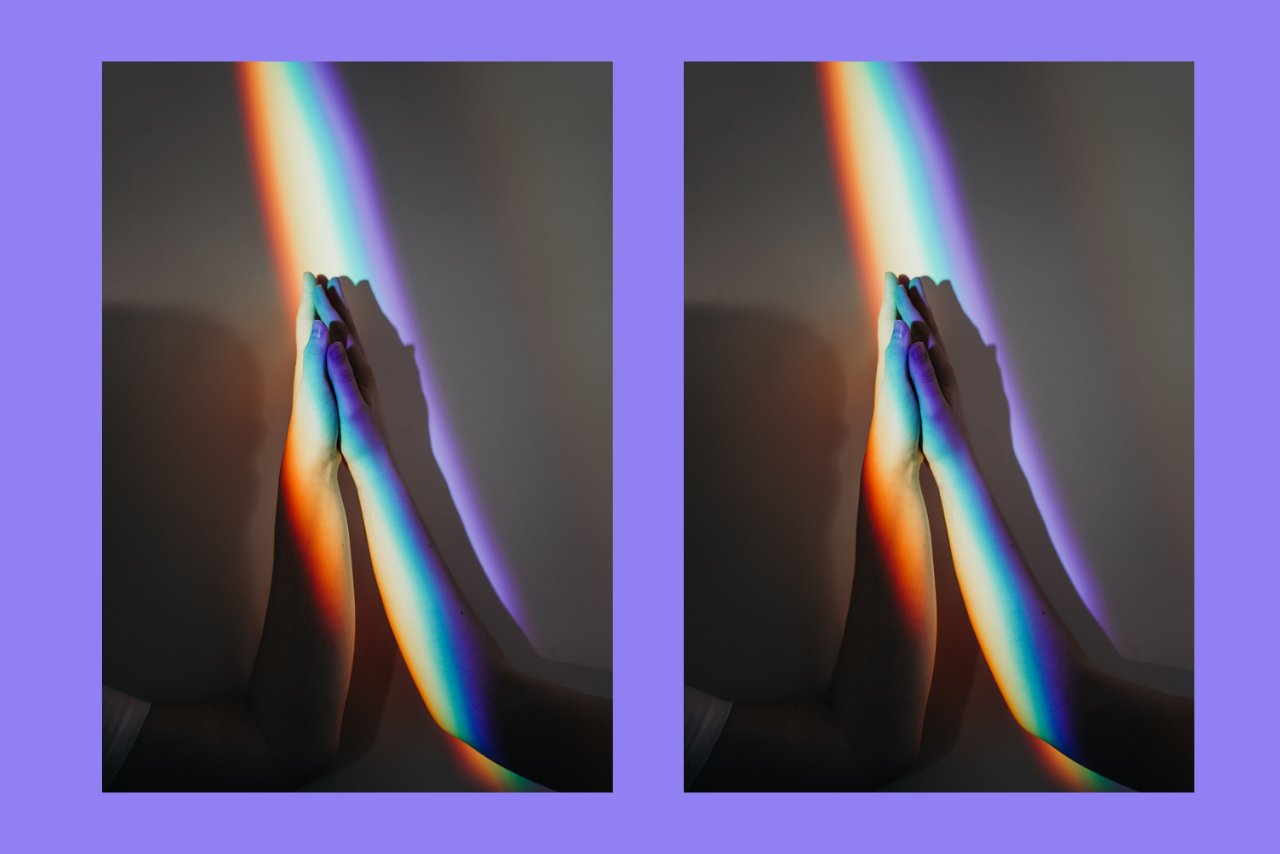 hands touching under rainbow shadow