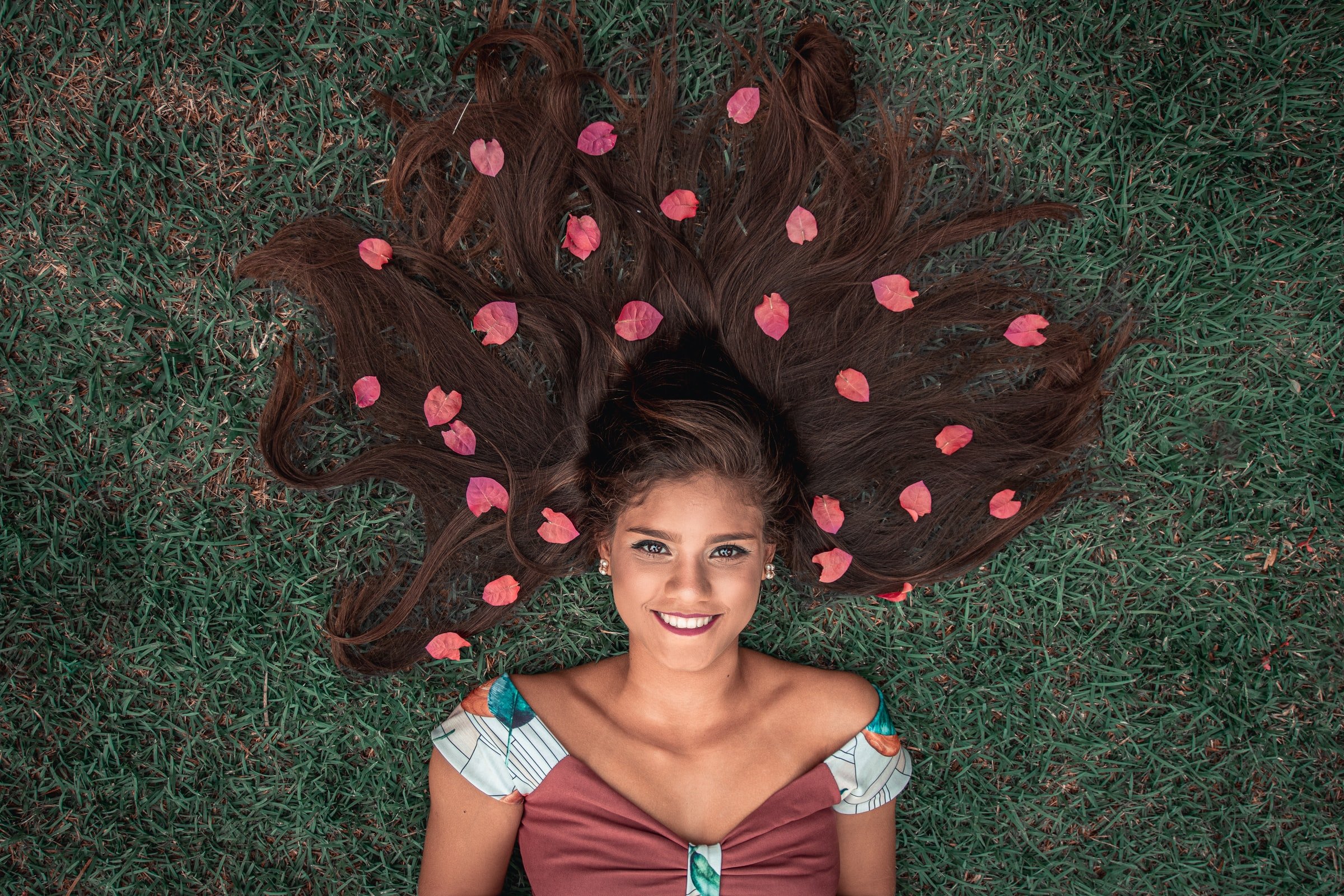 Woman laying in grass, flowers in her hair