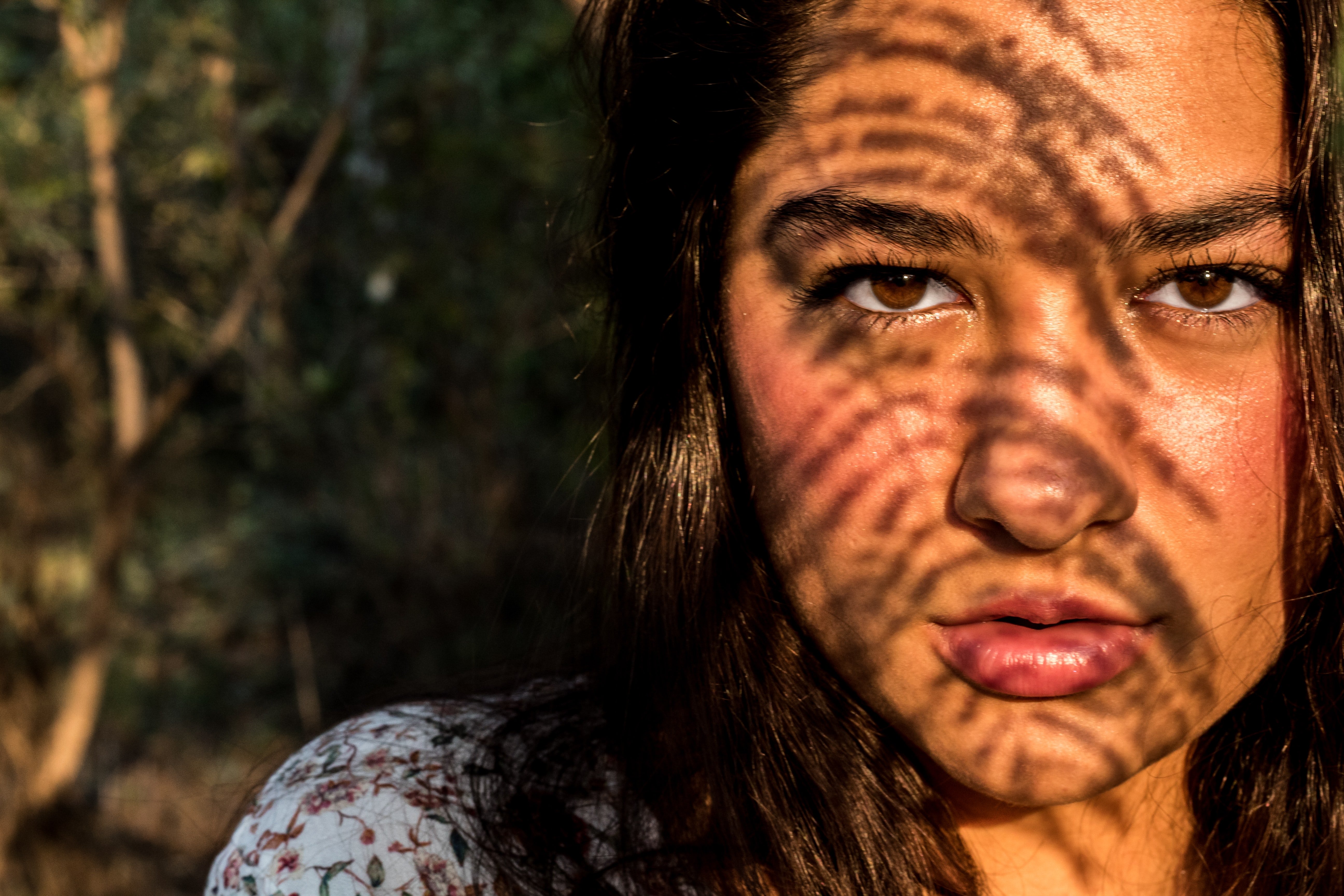 Woman with plant shadows on her face