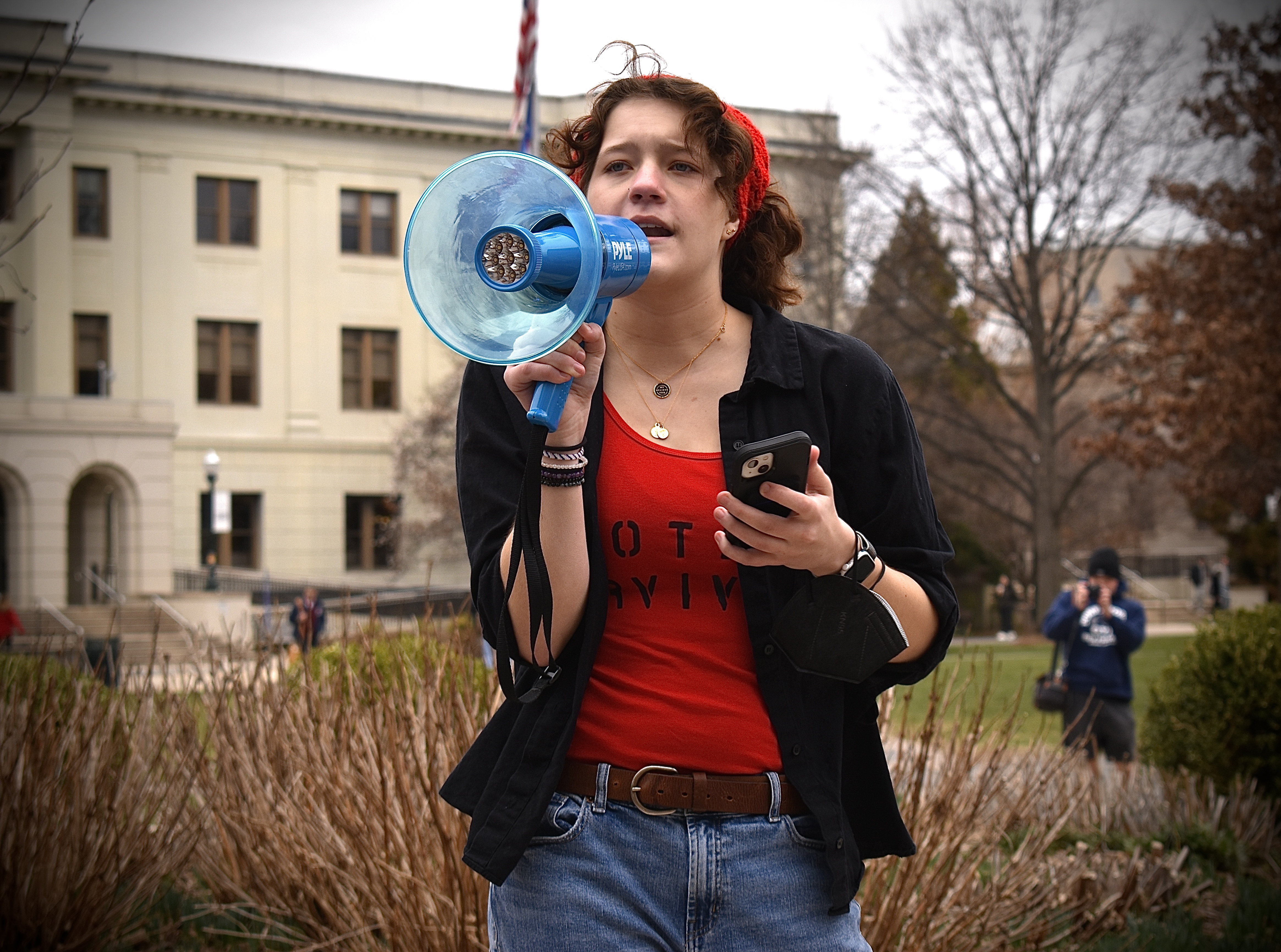 College-aged woman speaking with a bullhorn at a protest.