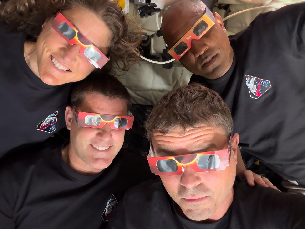 Mission Specialist Christina Koch (top left), Mission Specialist Jeremy Hansen (bottom left), Commander Reid Wiseman (bottom right), and Pilot Victor Glover (top right) – uses eclipse viewers