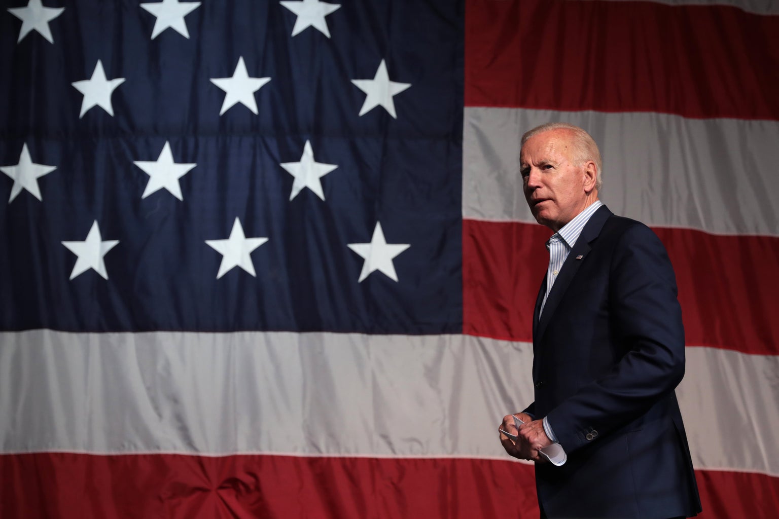 Joe Biden speaking in front of an American flag