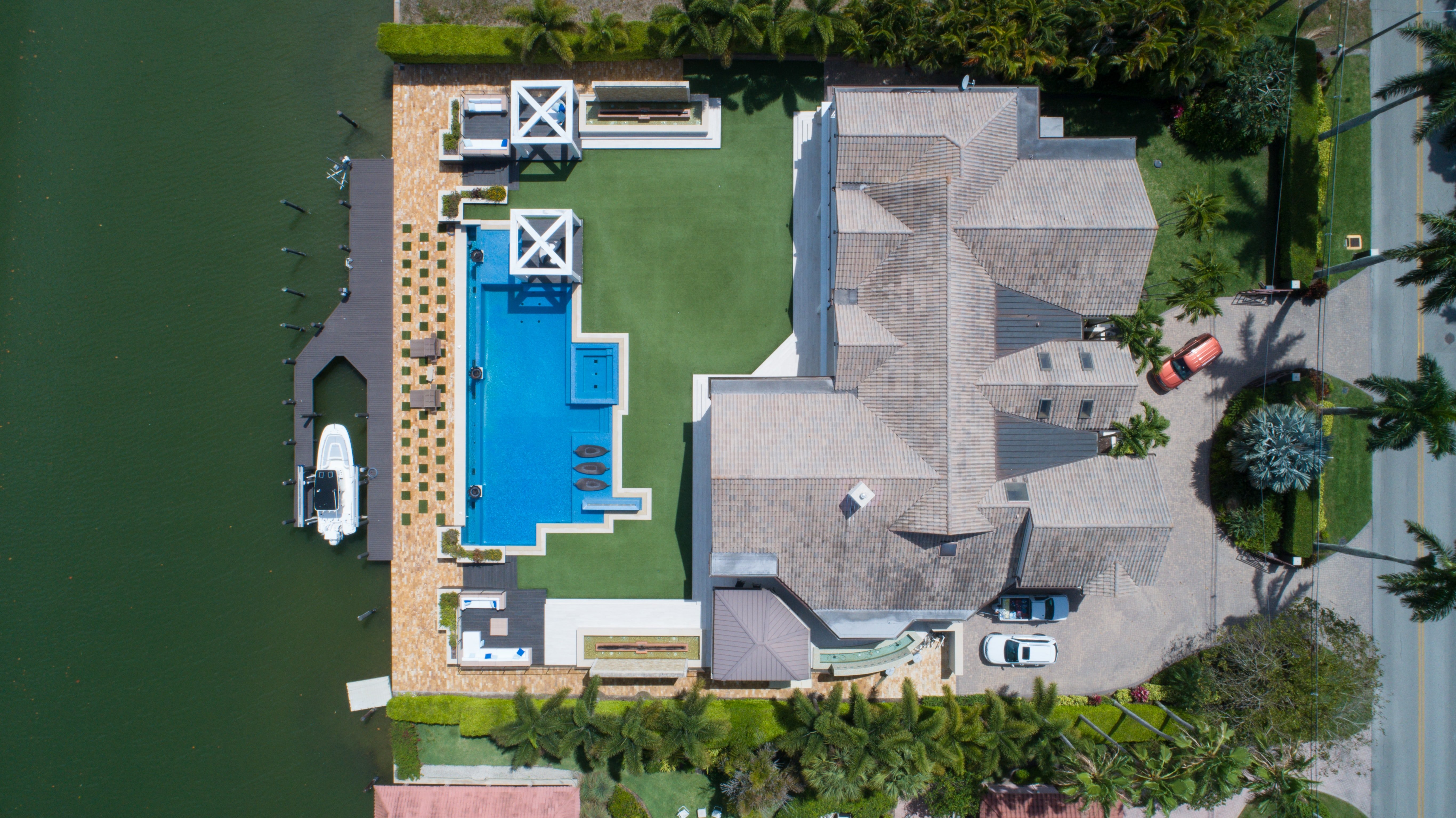 bird\'s eye view of house with pool near body of water