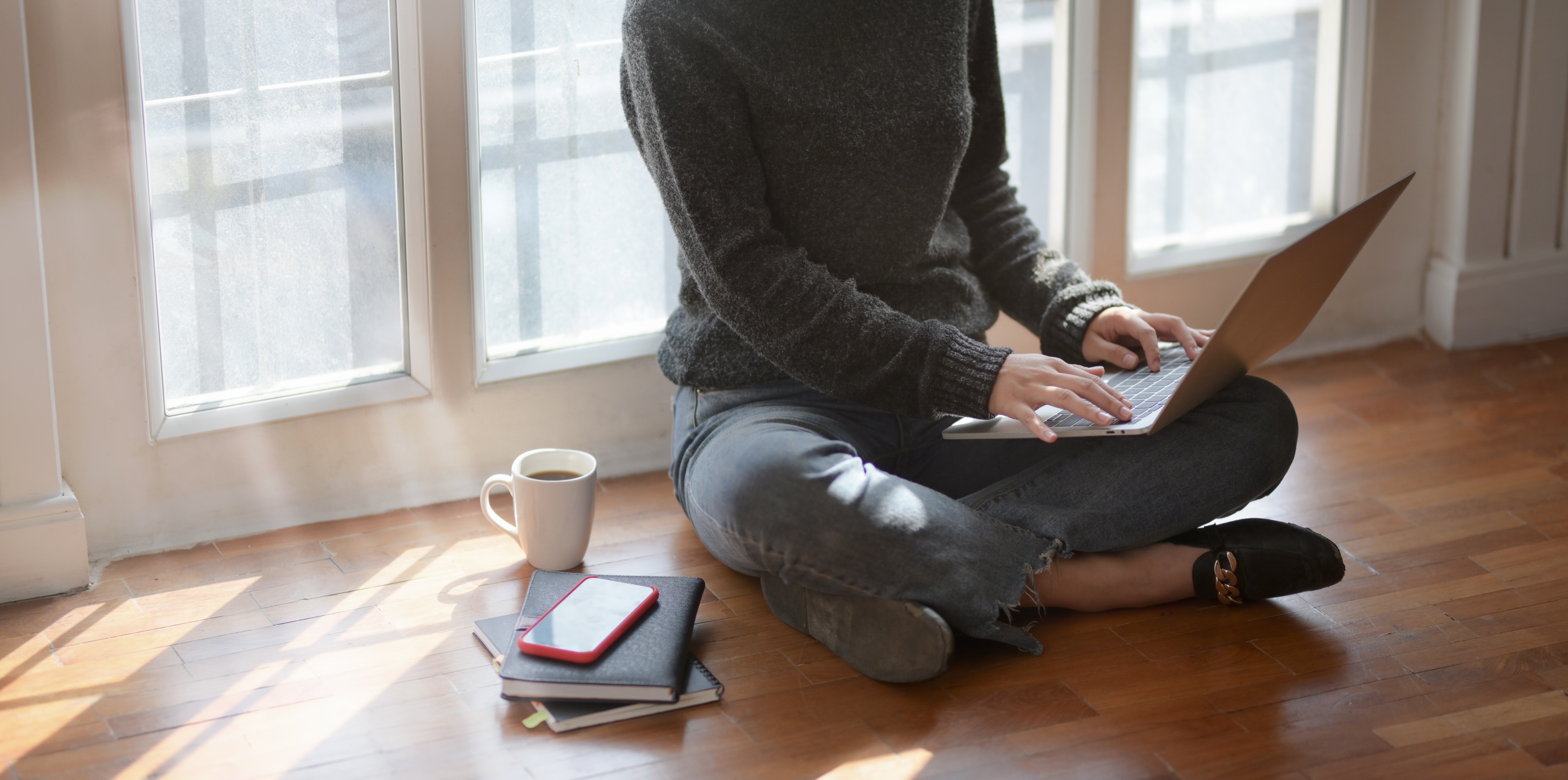 Woman with laptop beside window
