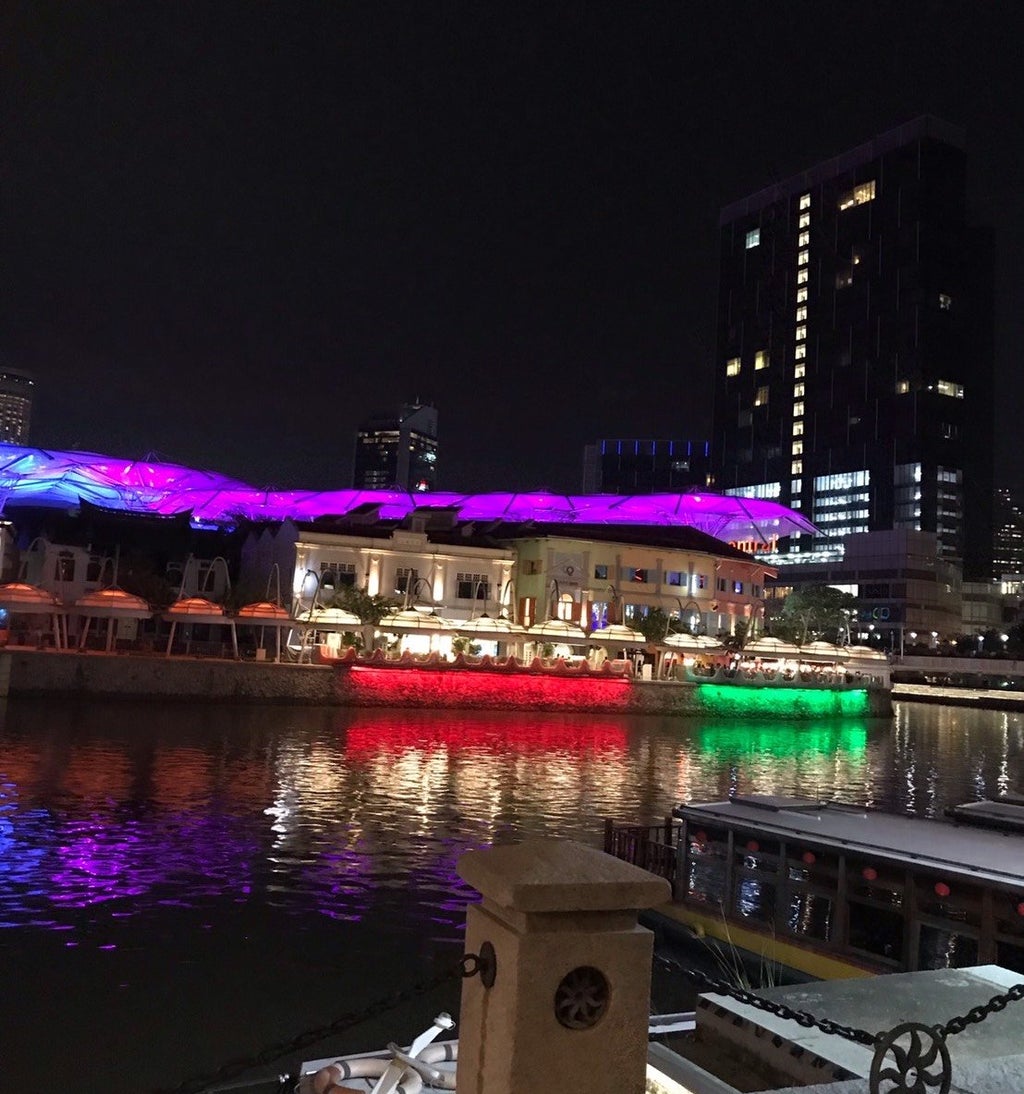 image of a dock lit up at night by red, green, and purple lights