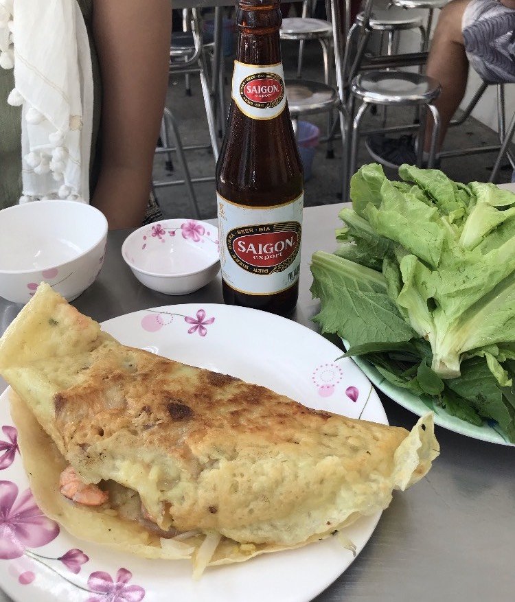 Plate of folded fried dish, plate of lettuce, and bottle of veer