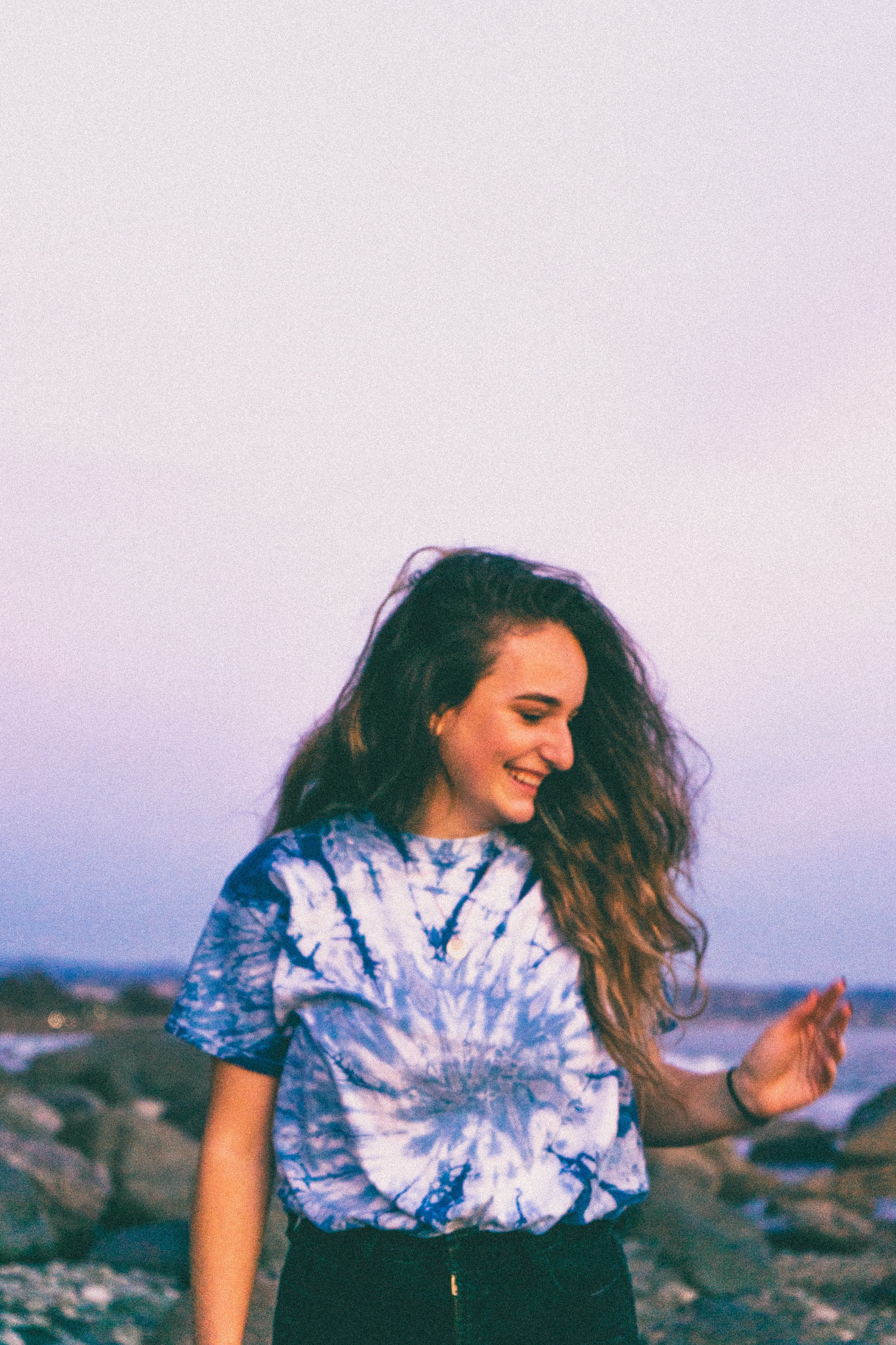 woman in white and blue shirt standing on shore