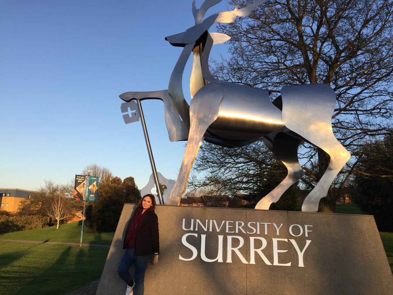 Woman standing in front of statue at British university campus