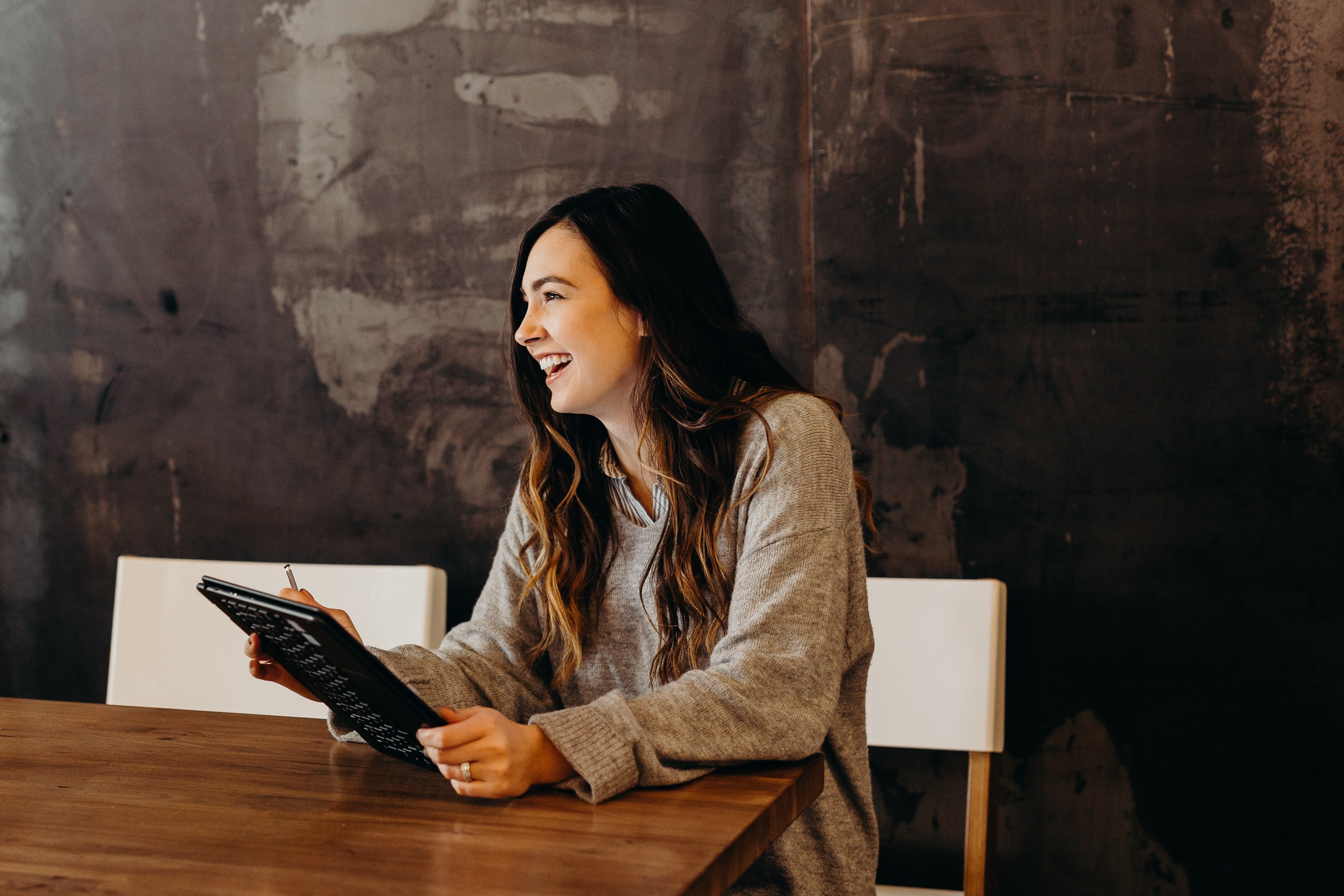 Woman sitting at a table holding a notebook