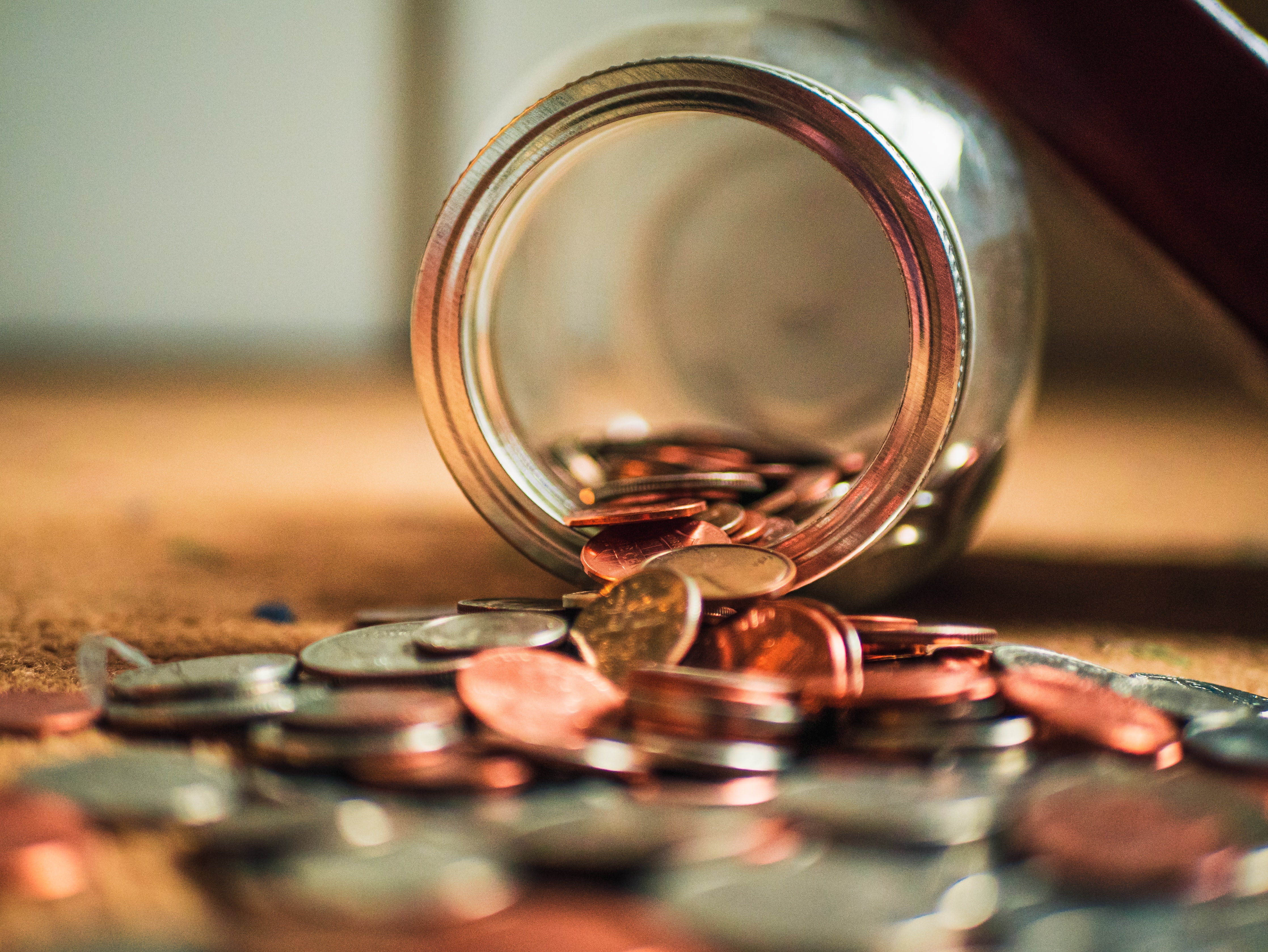 Pile of US coins spilling out of glass jar