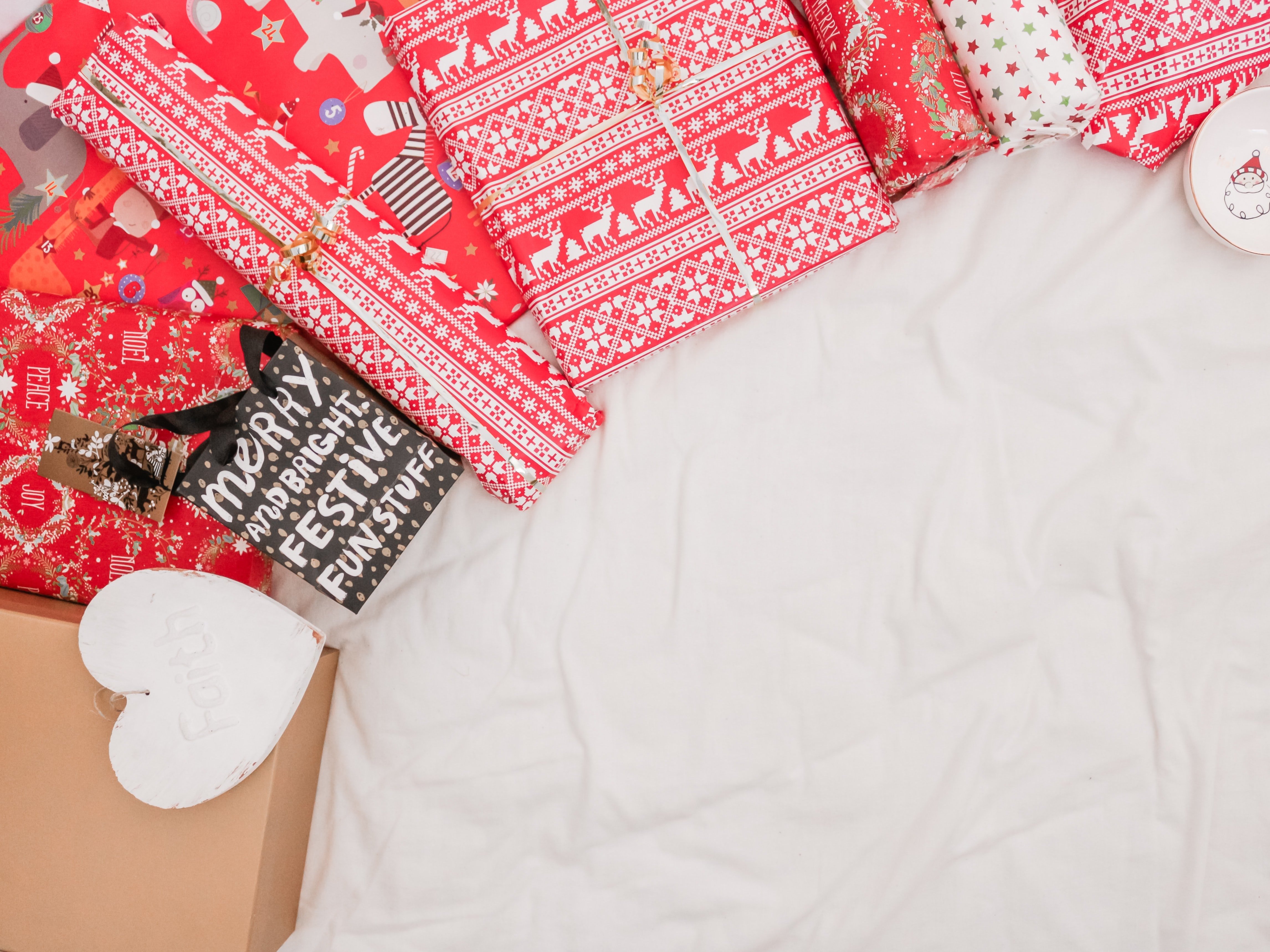 red and black packed presents on white textile
