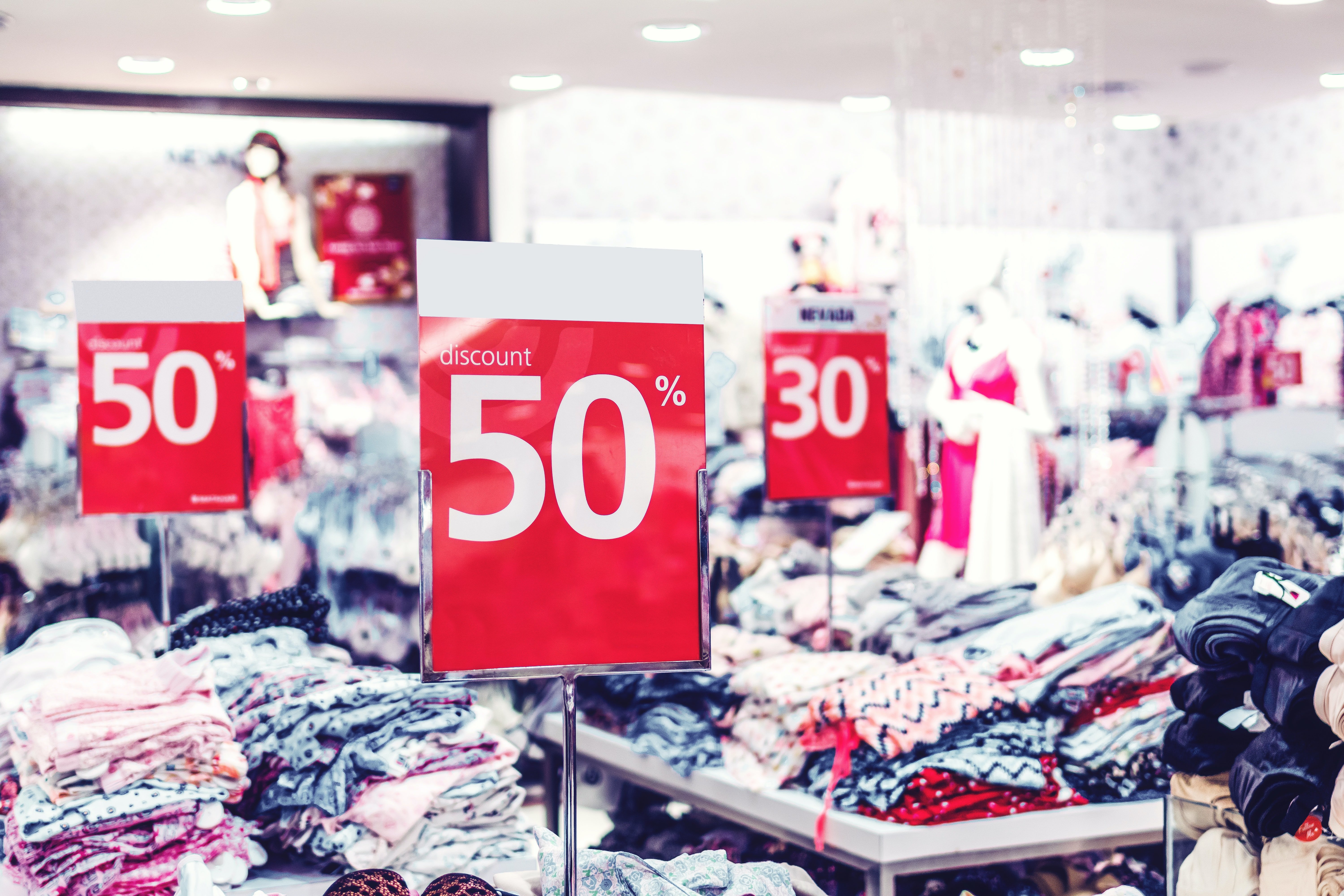 Sale signs at store by Artem Beliaiken