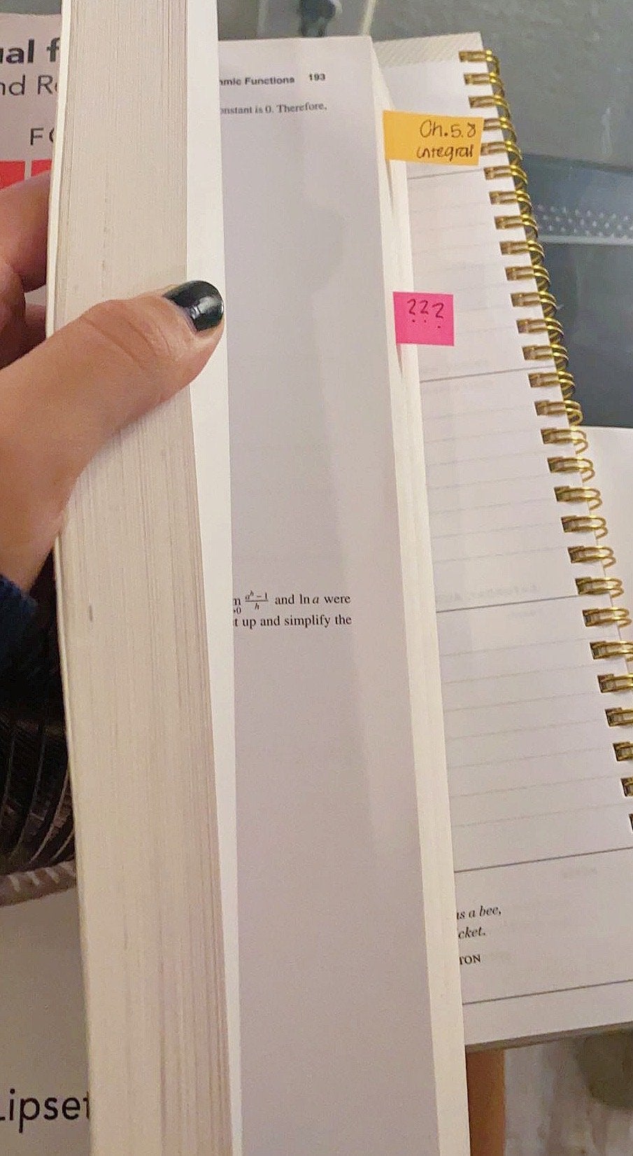 Student holding open a textbook with sticky notes