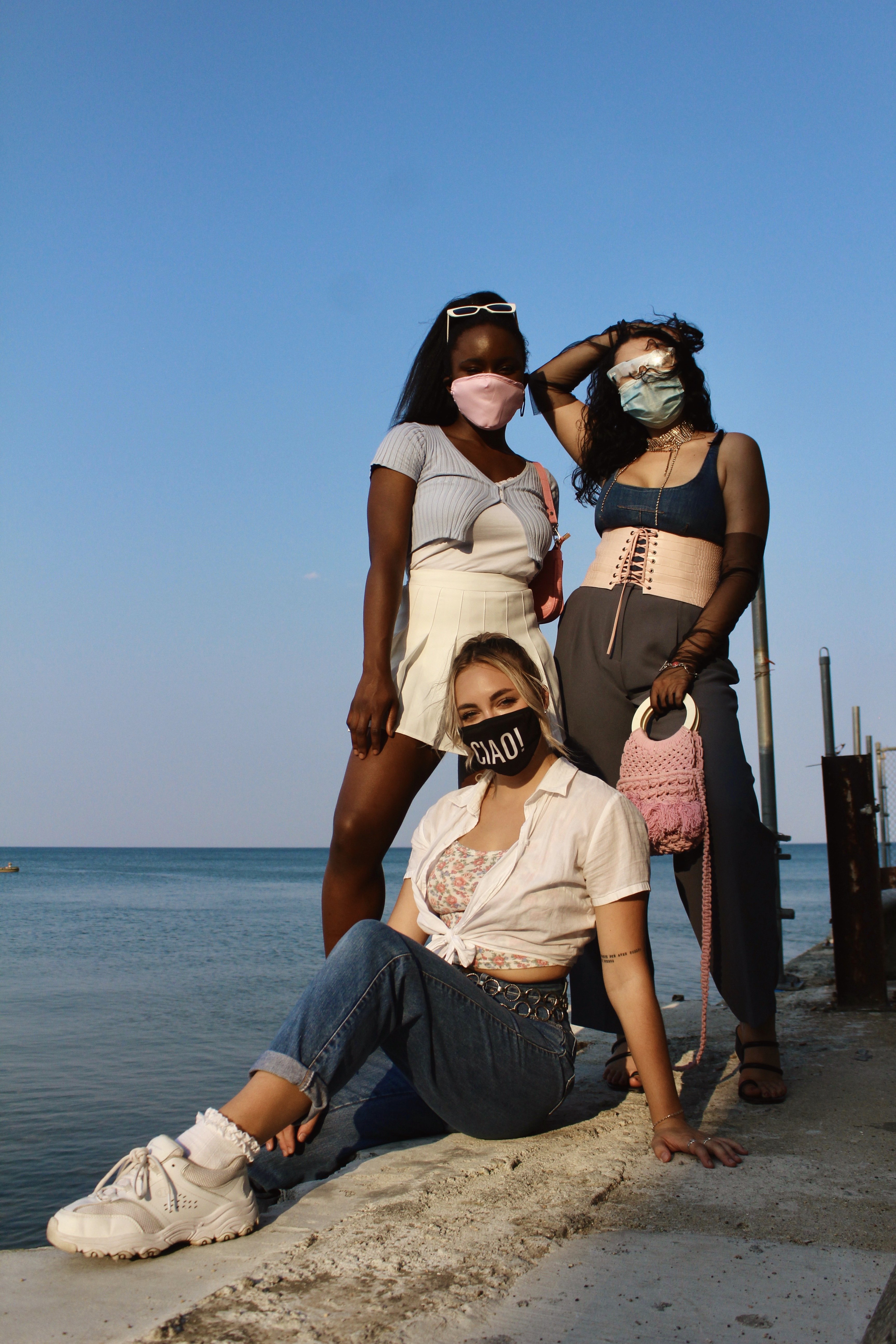 Three women in fashion trends in front of lake