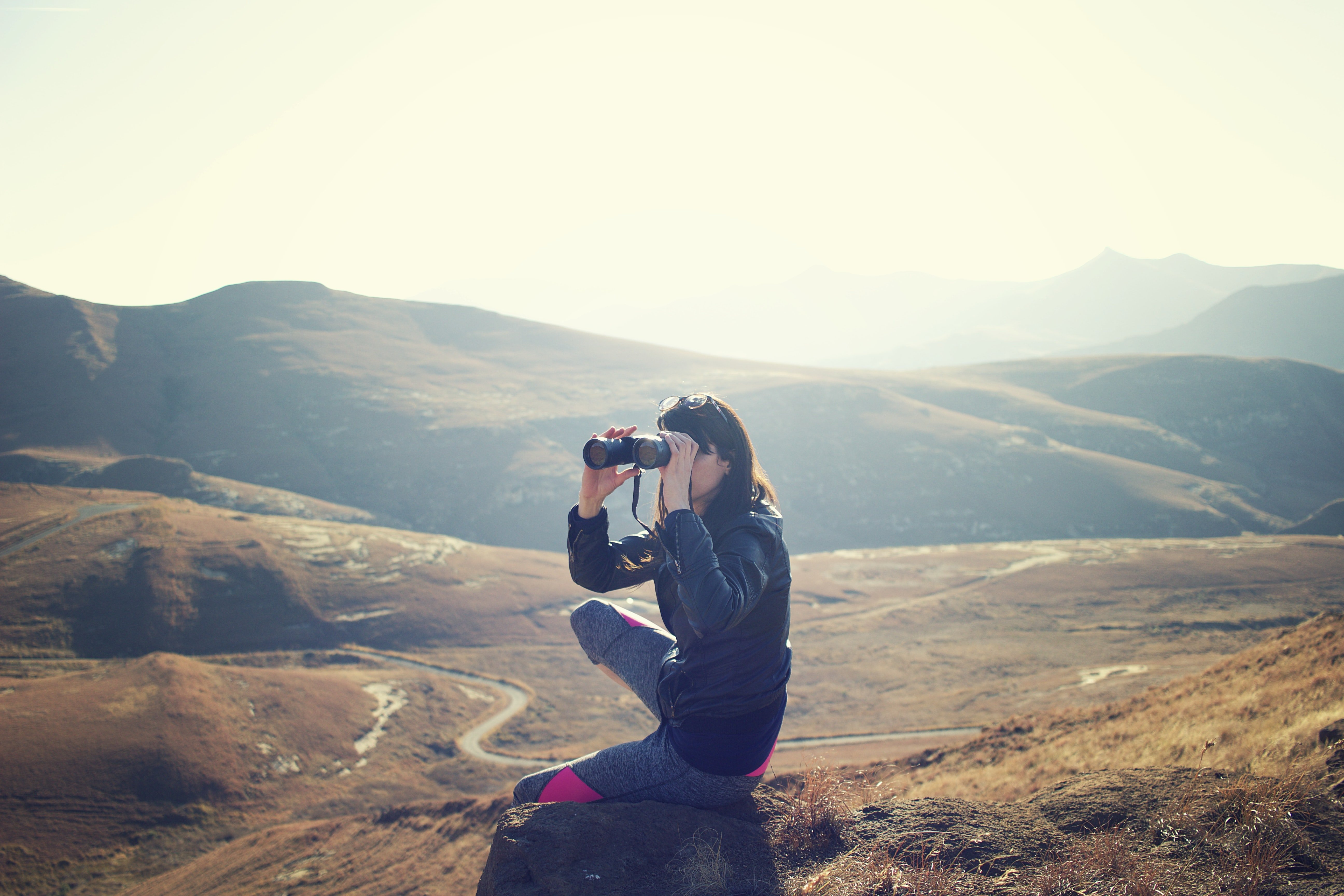 woman using binoculars on mountains by Pawel Janiak via unsplash