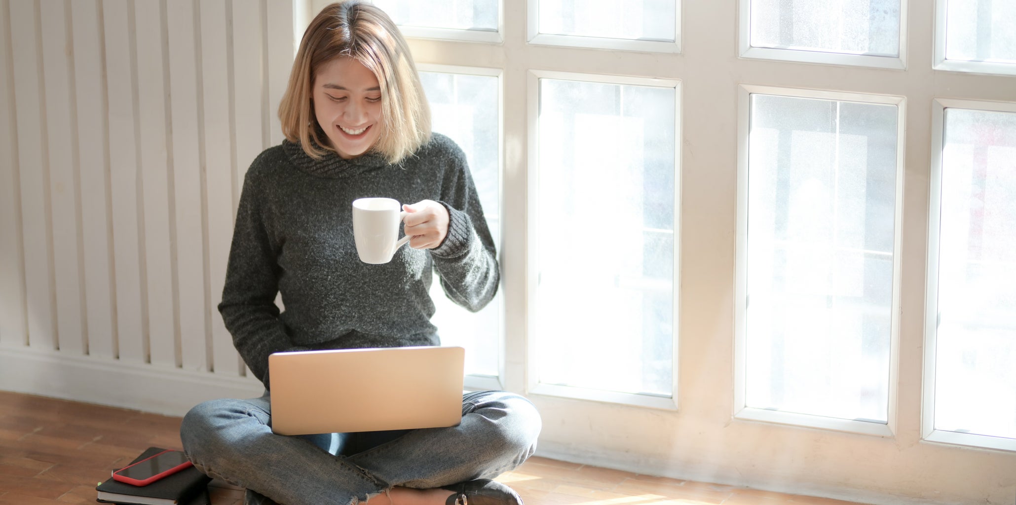 Woman sitting at computer drinking coffee
