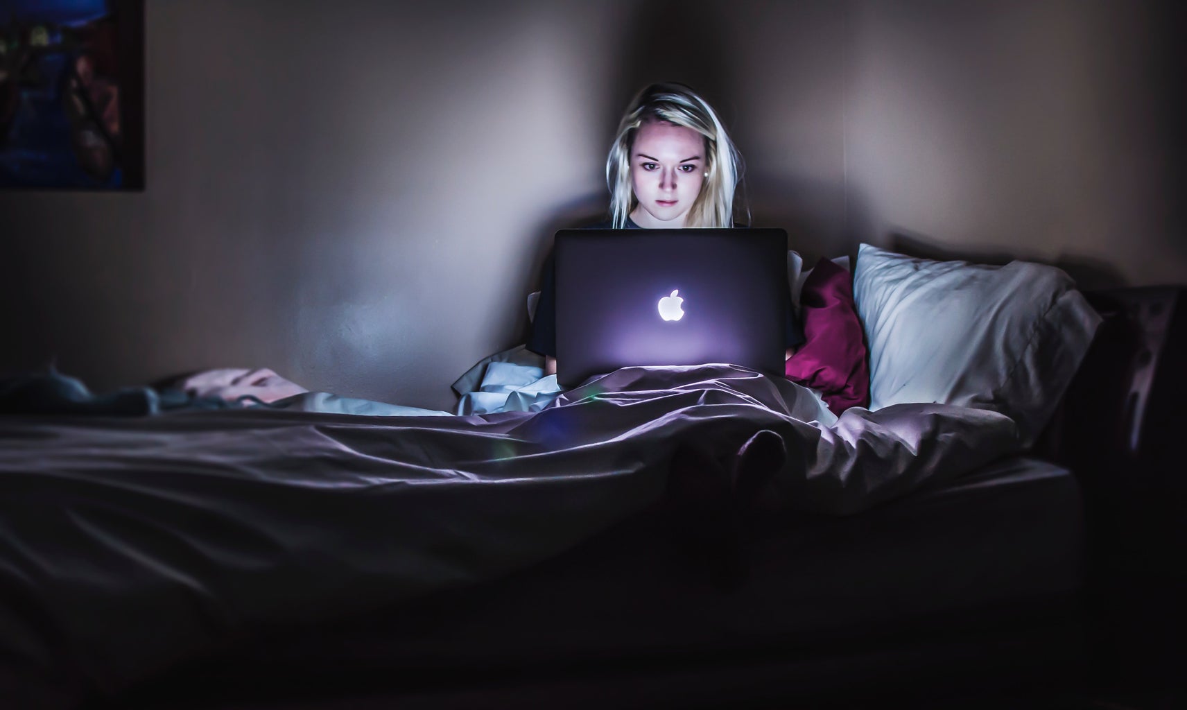 Person in bed at night on computer