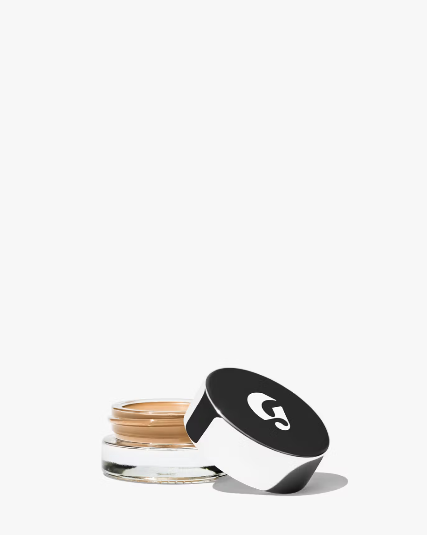 Glossier stretch pot concealer in a medium shade, silver lid of the pot in a white background