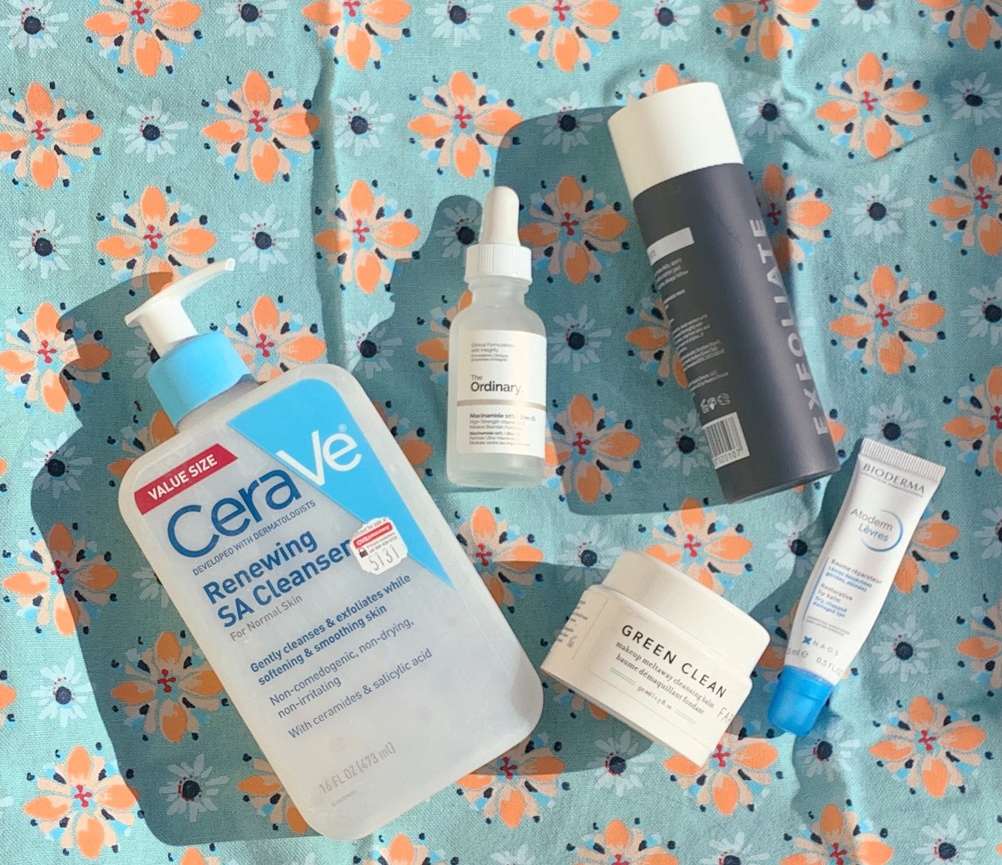 Skincare products are displayed on a floral background.