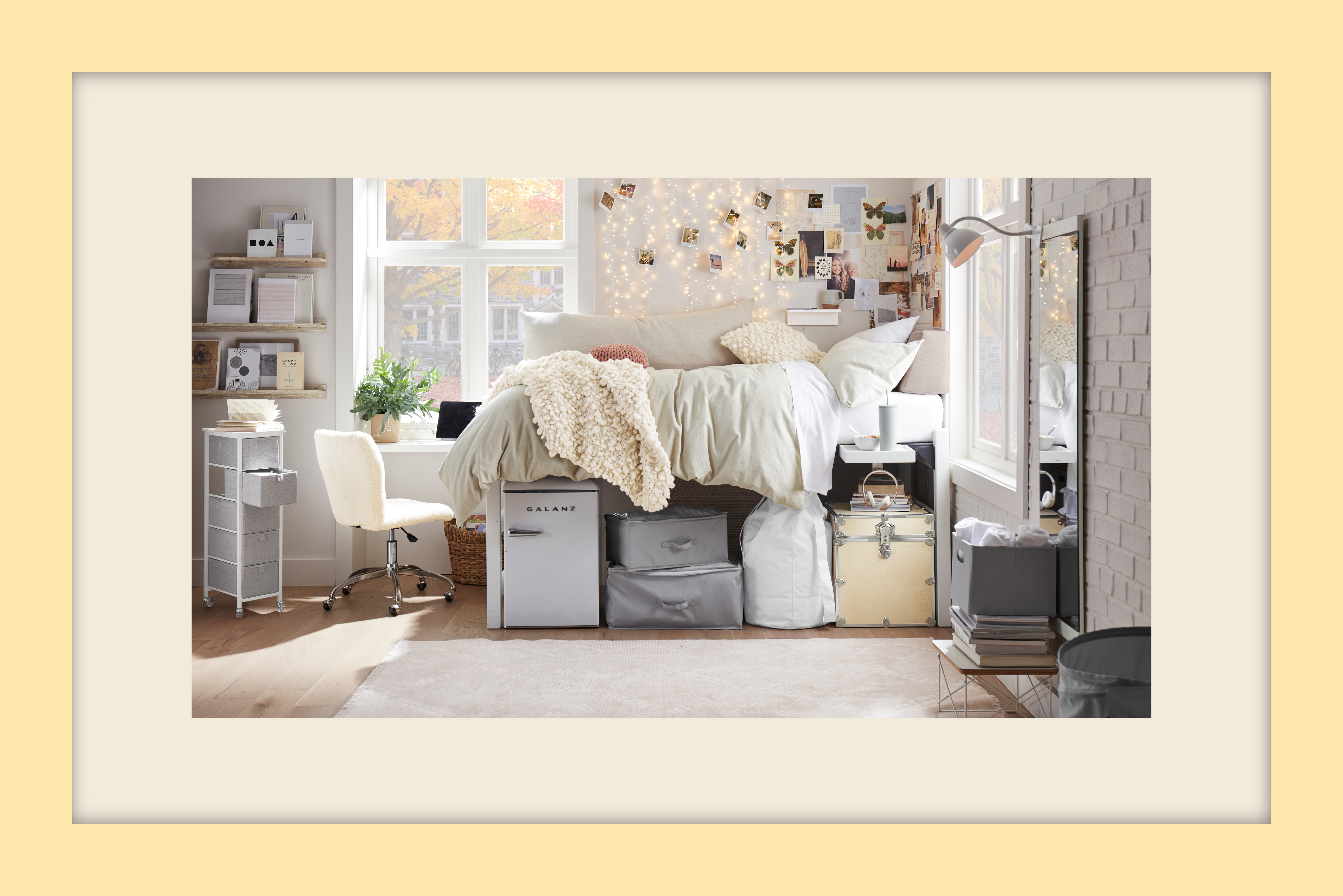 Dorm room with a bed, fairy lights, pictures, storage, and a desk chair.
