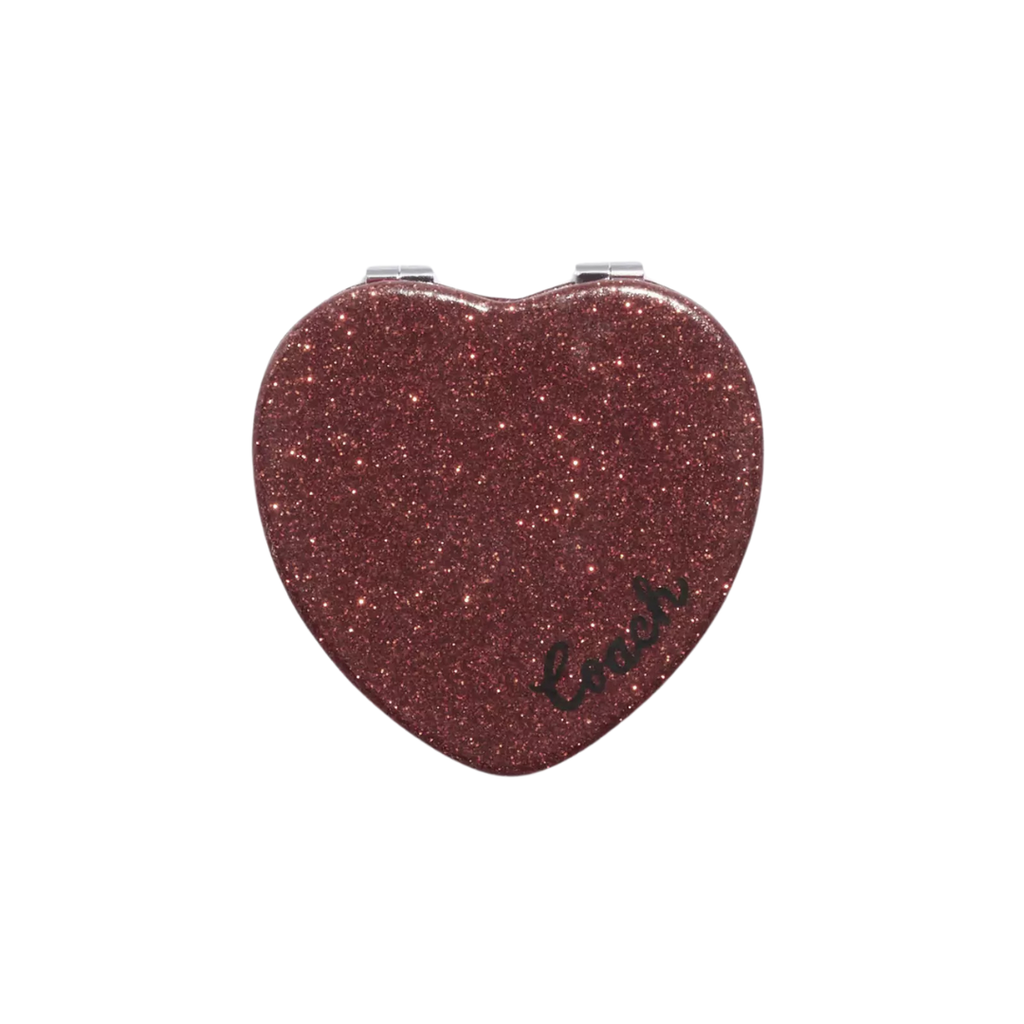 A dark red sparkly compact mirror in the shape of a heart