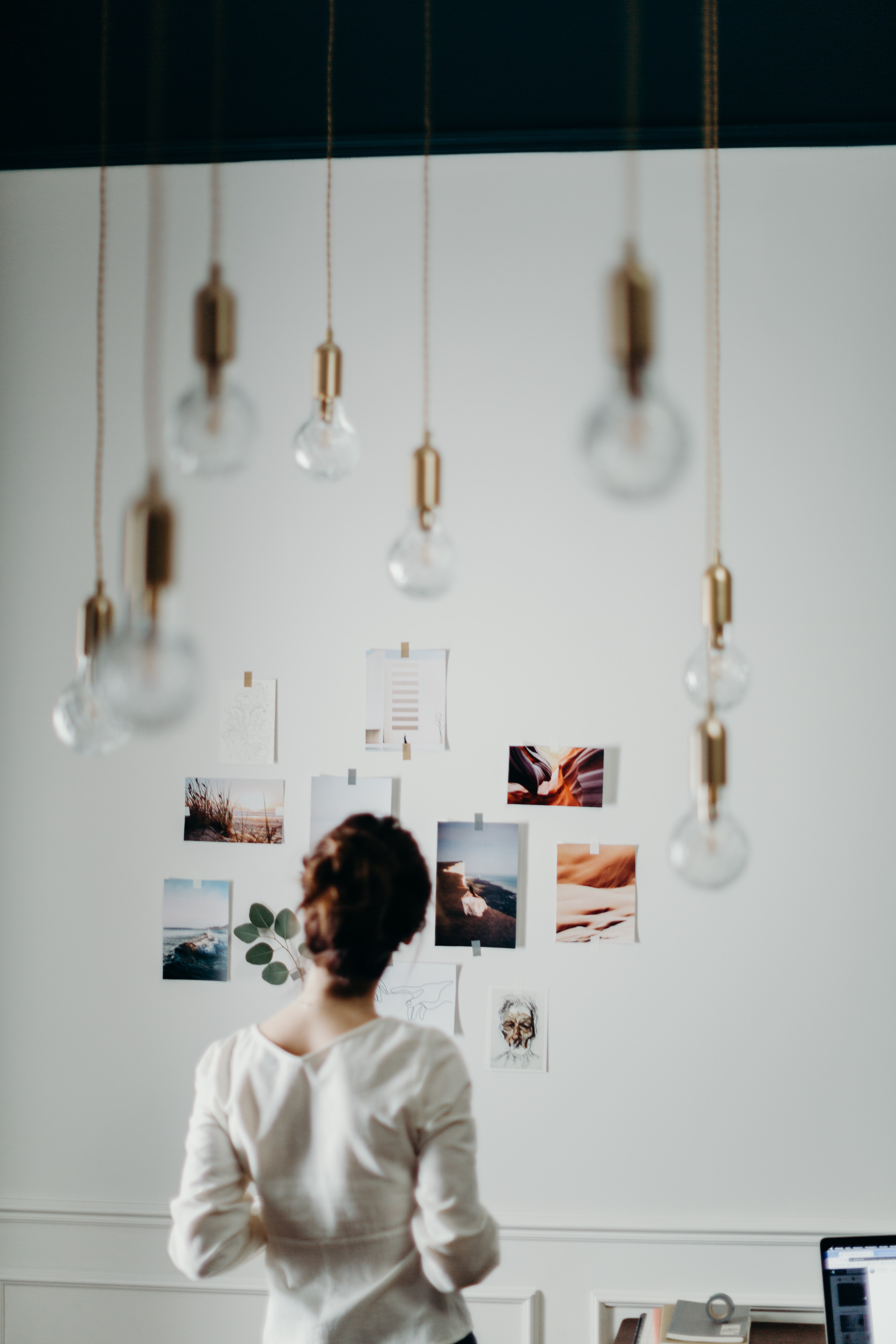woman wearing blouse looking at photos on wall