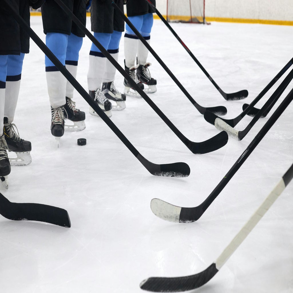 Men playing hockey with sticks and skates