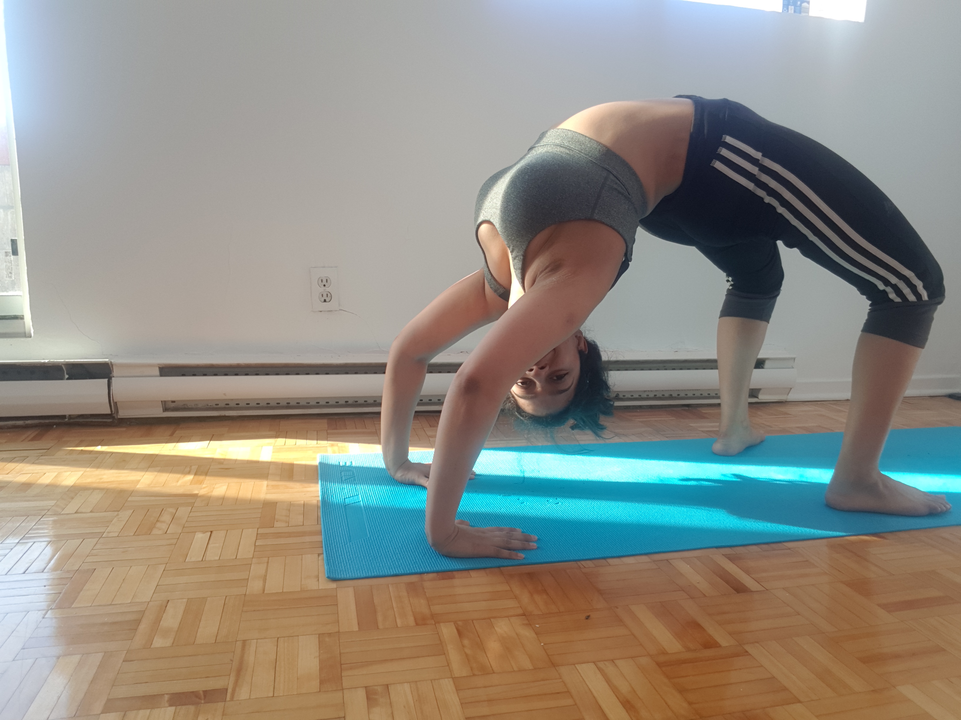 Woman doing chakrasana, or wheel pose.