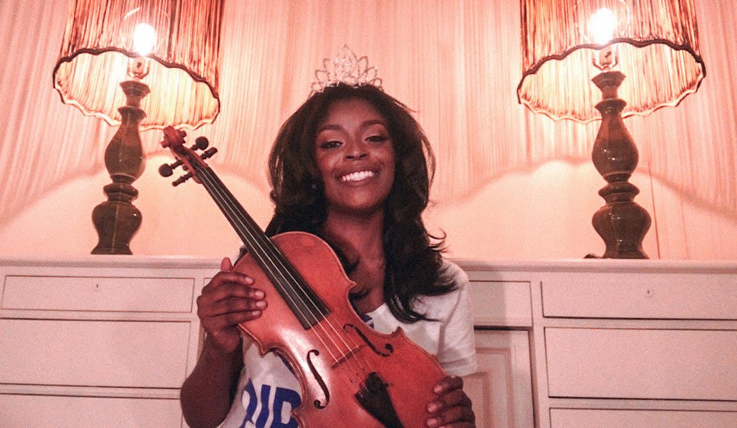 The new Miss Hampton holds up her violin
