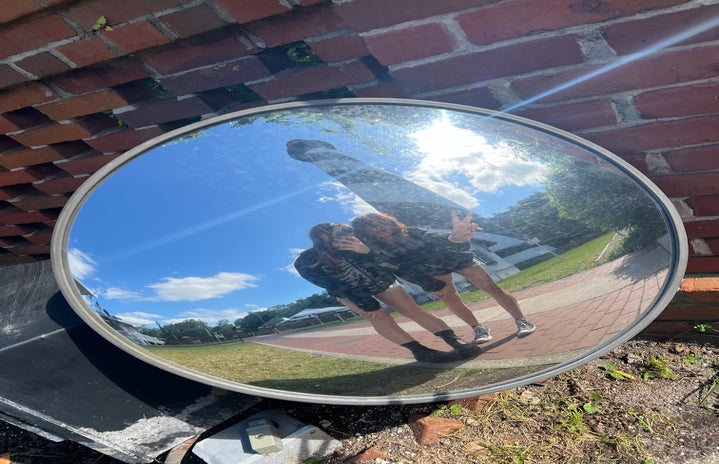 Two girls post for a photo in front of the St. Augustine Lighthouse